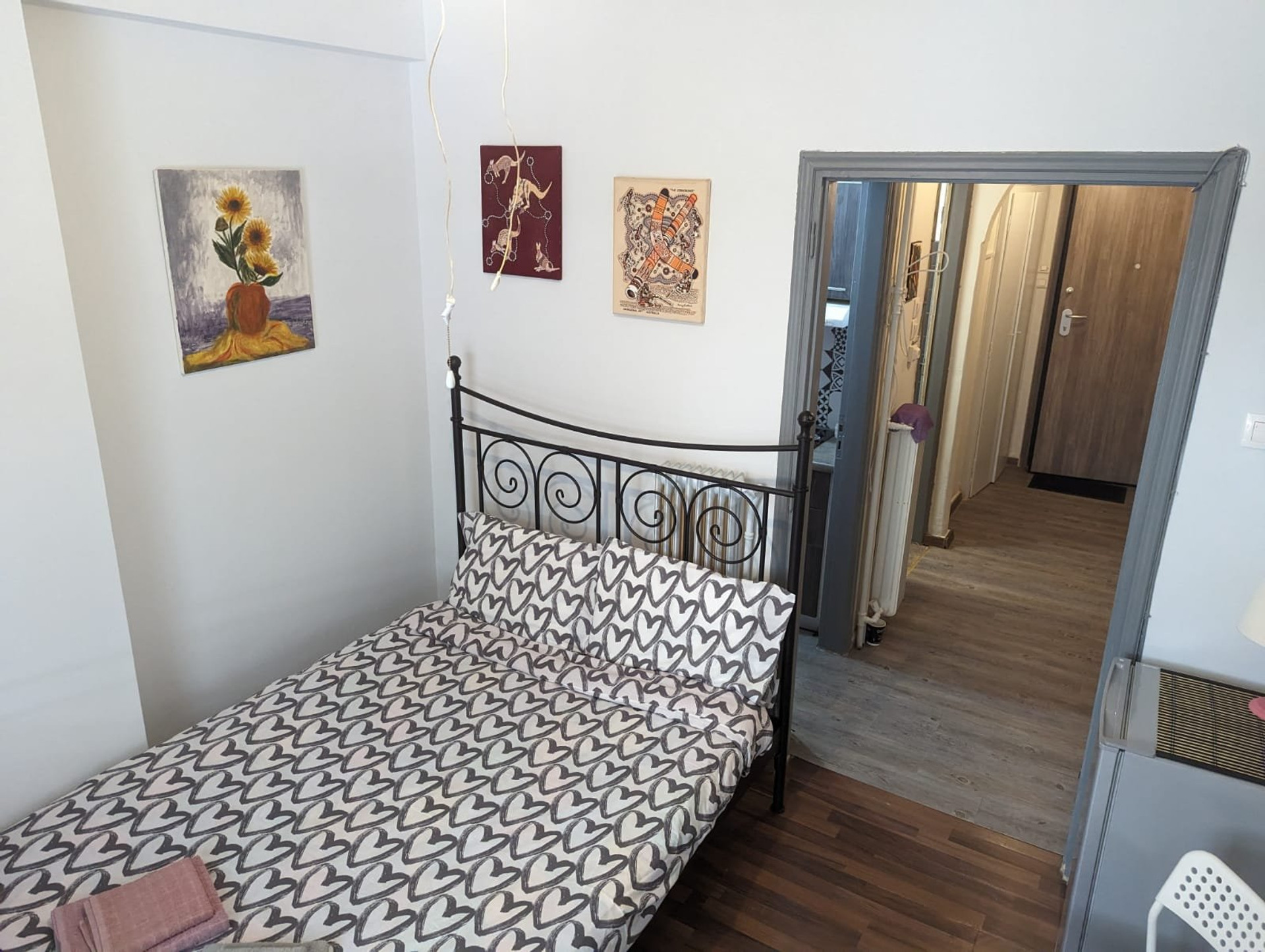 Bedroom with iron bed and artwork