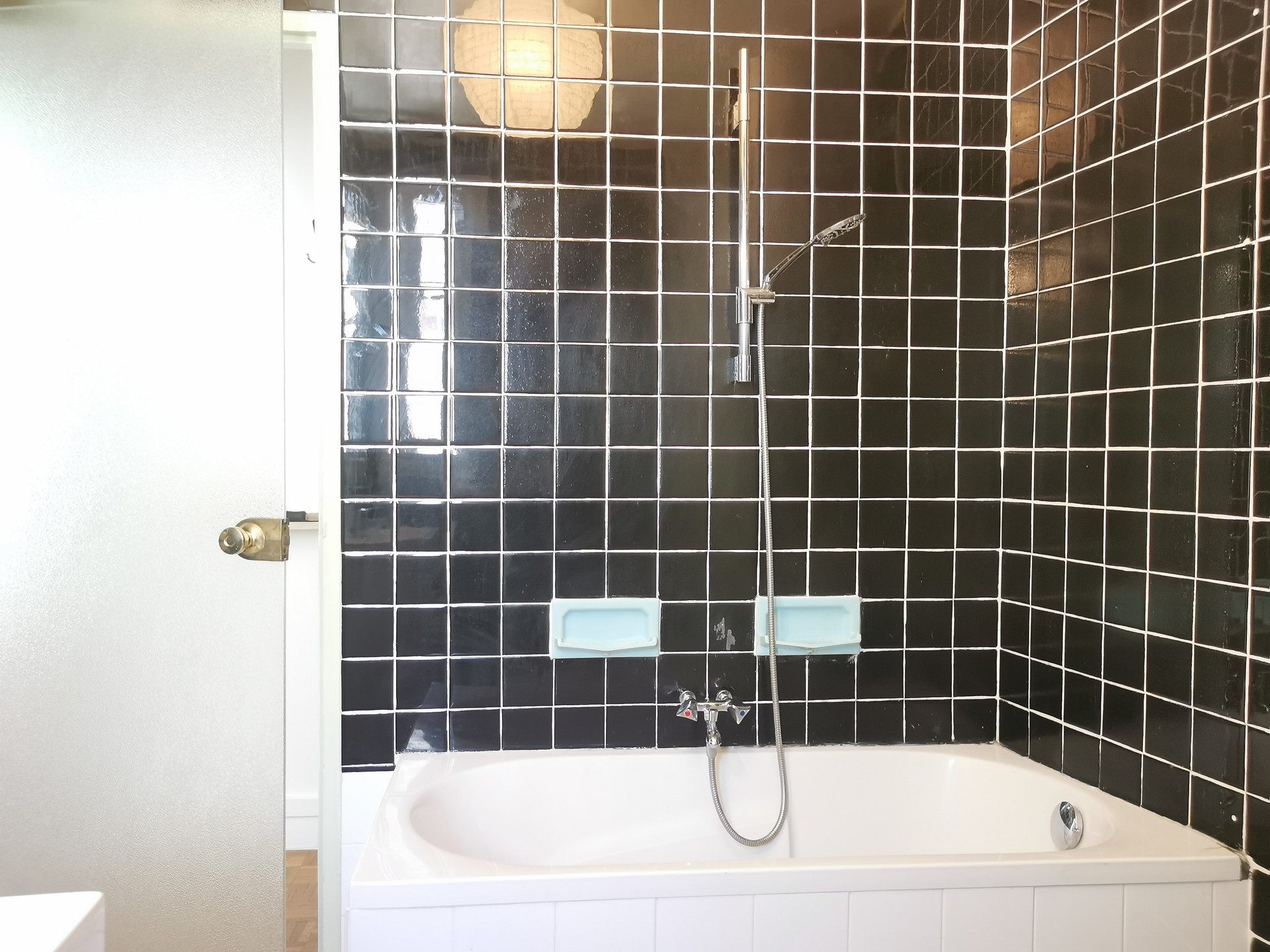 Bathroom tub with black tiles