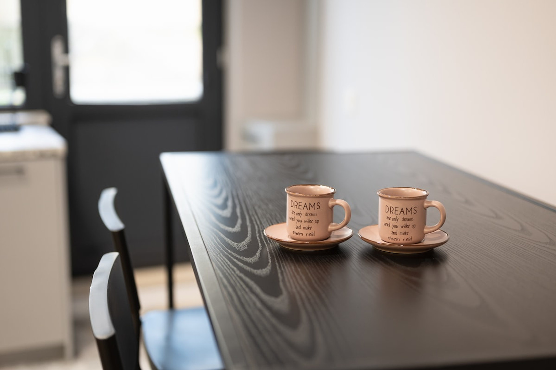 Warm and inviting moment with two coffee cups placed on a dark wooden table, adding a cozy touch to the space.