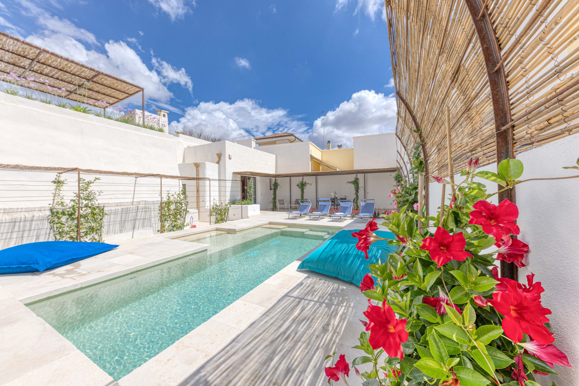 Pool and sun loungers with flowers