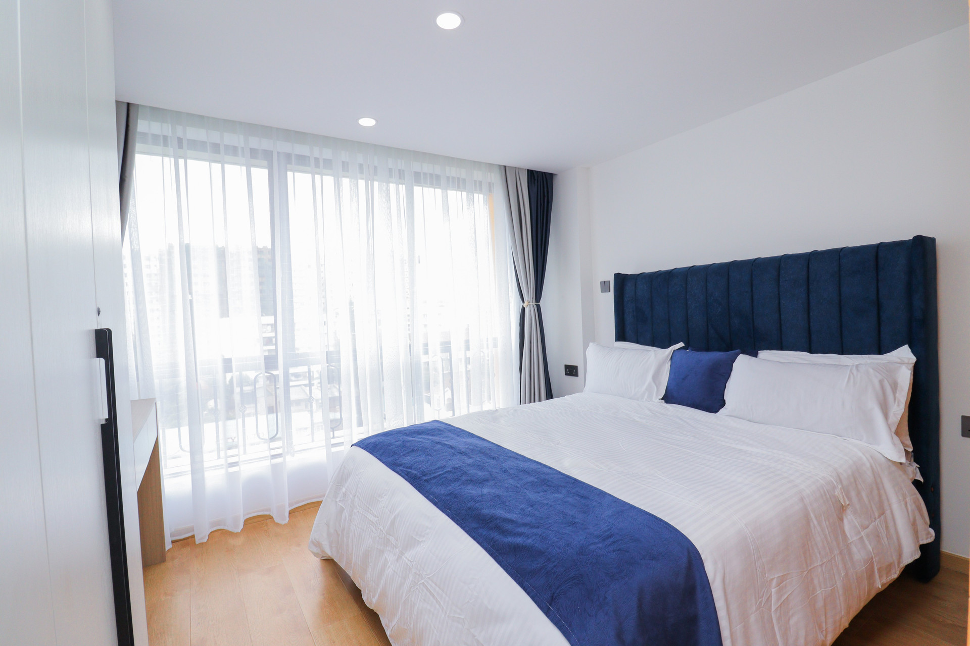 Bedroom with blue headboard, balcony