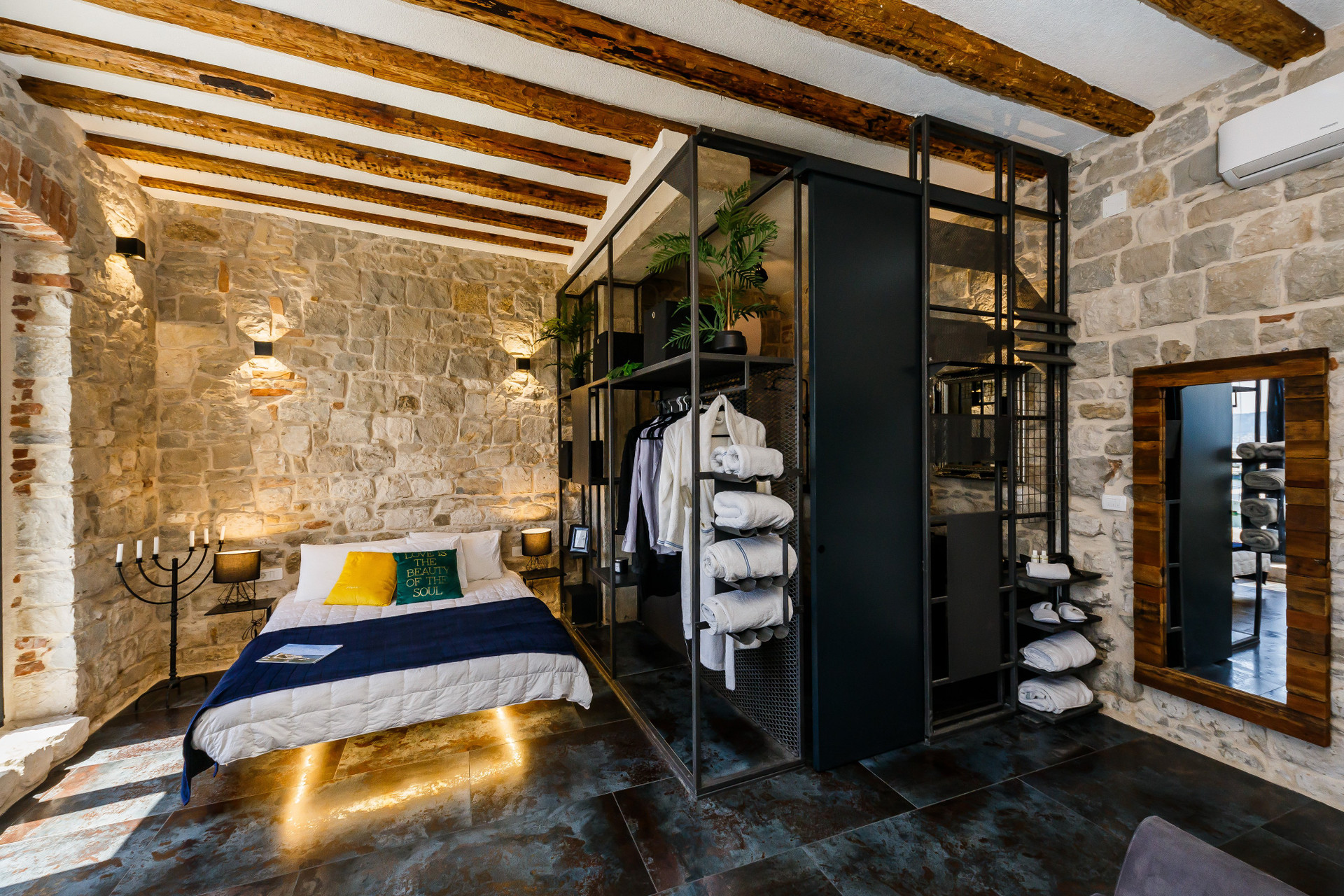 Bedroom with stone walls open wardrobe