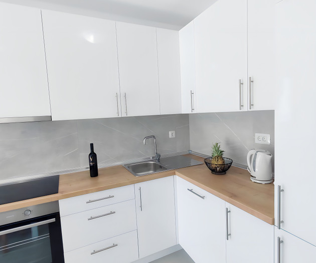 Modern white kitchen with wood counters