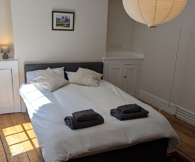 Bedroom with sunlit wood floors