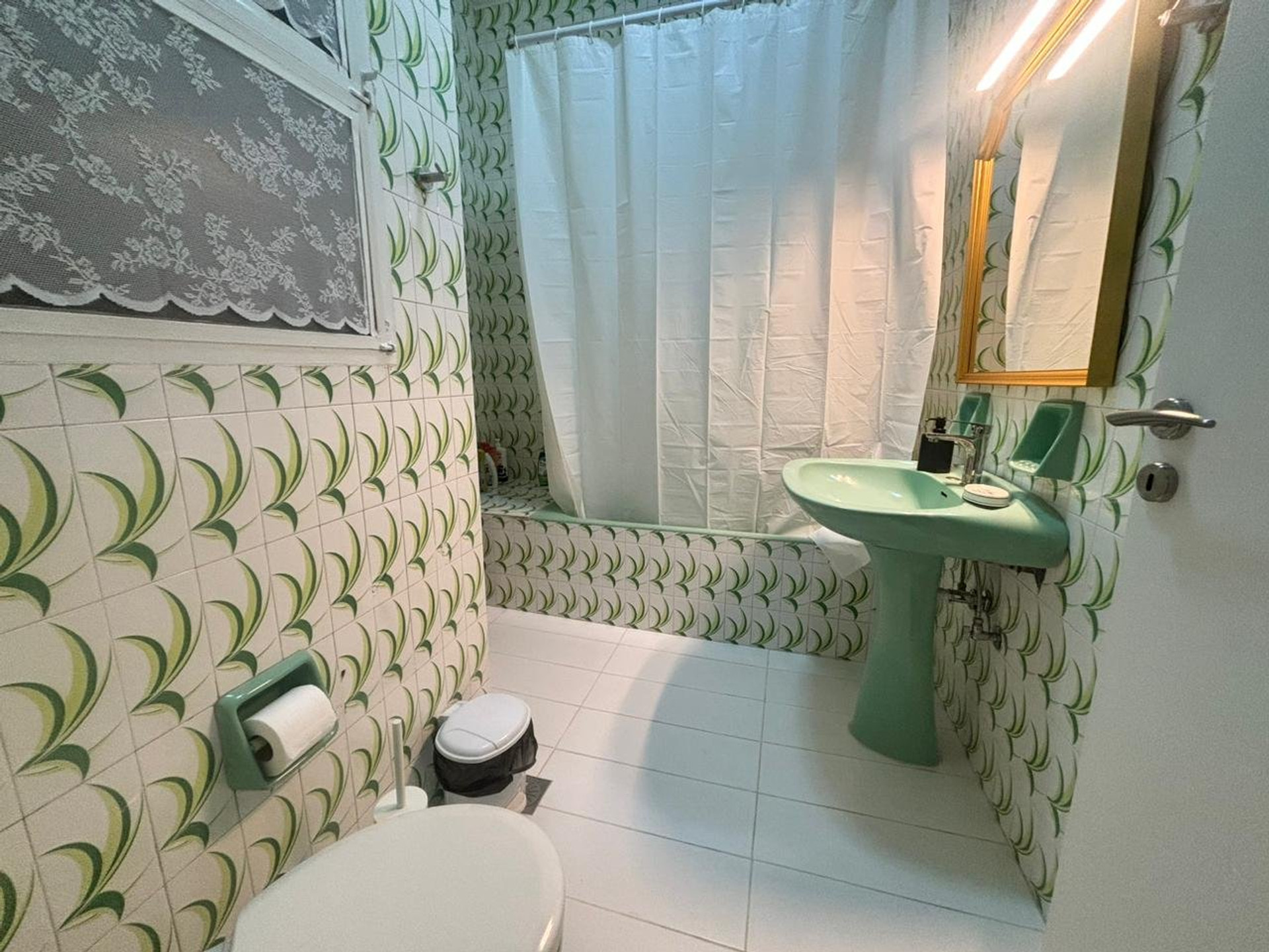 Bathroom with green tub and tiles