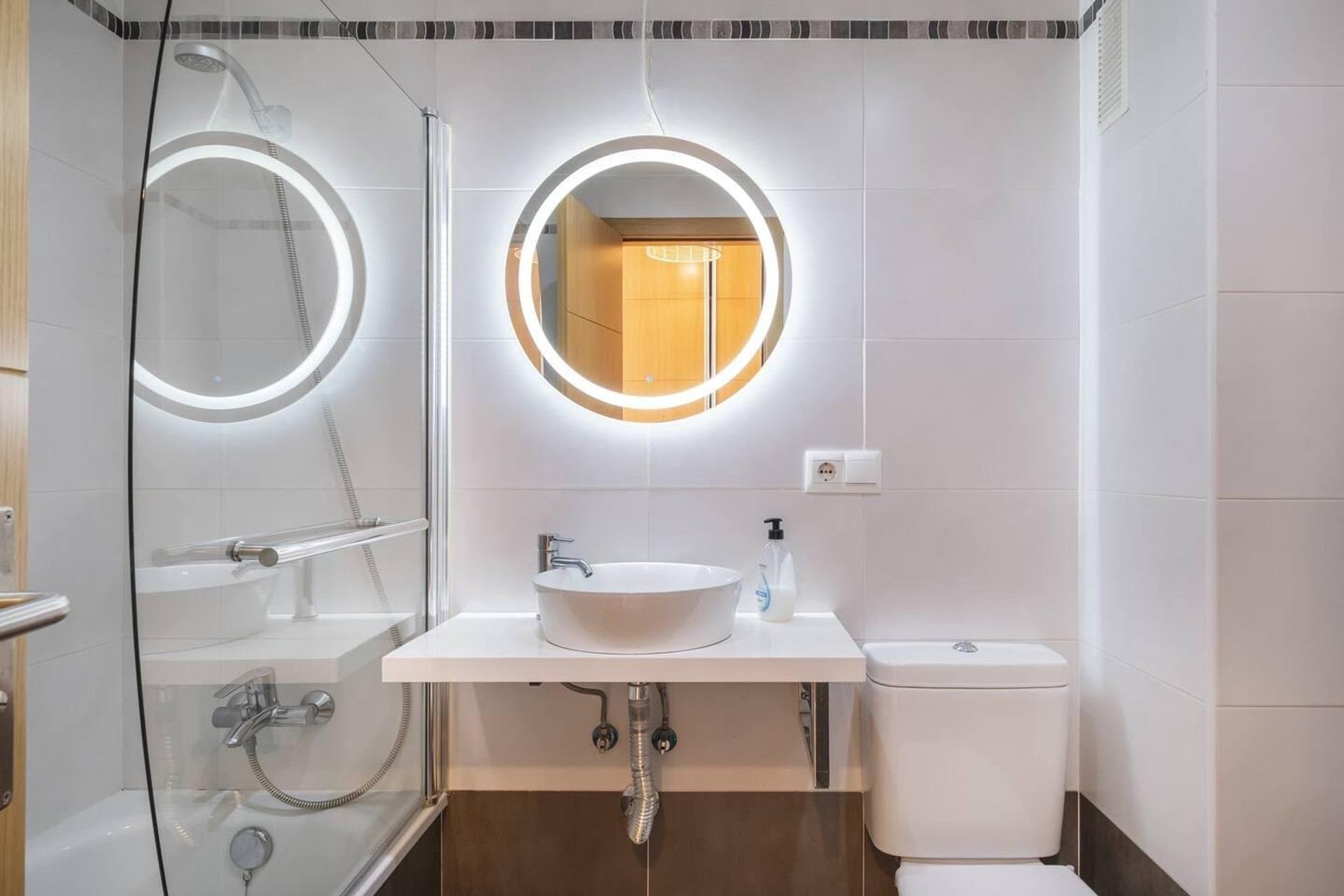 Bathroom with illuminated round mirrors