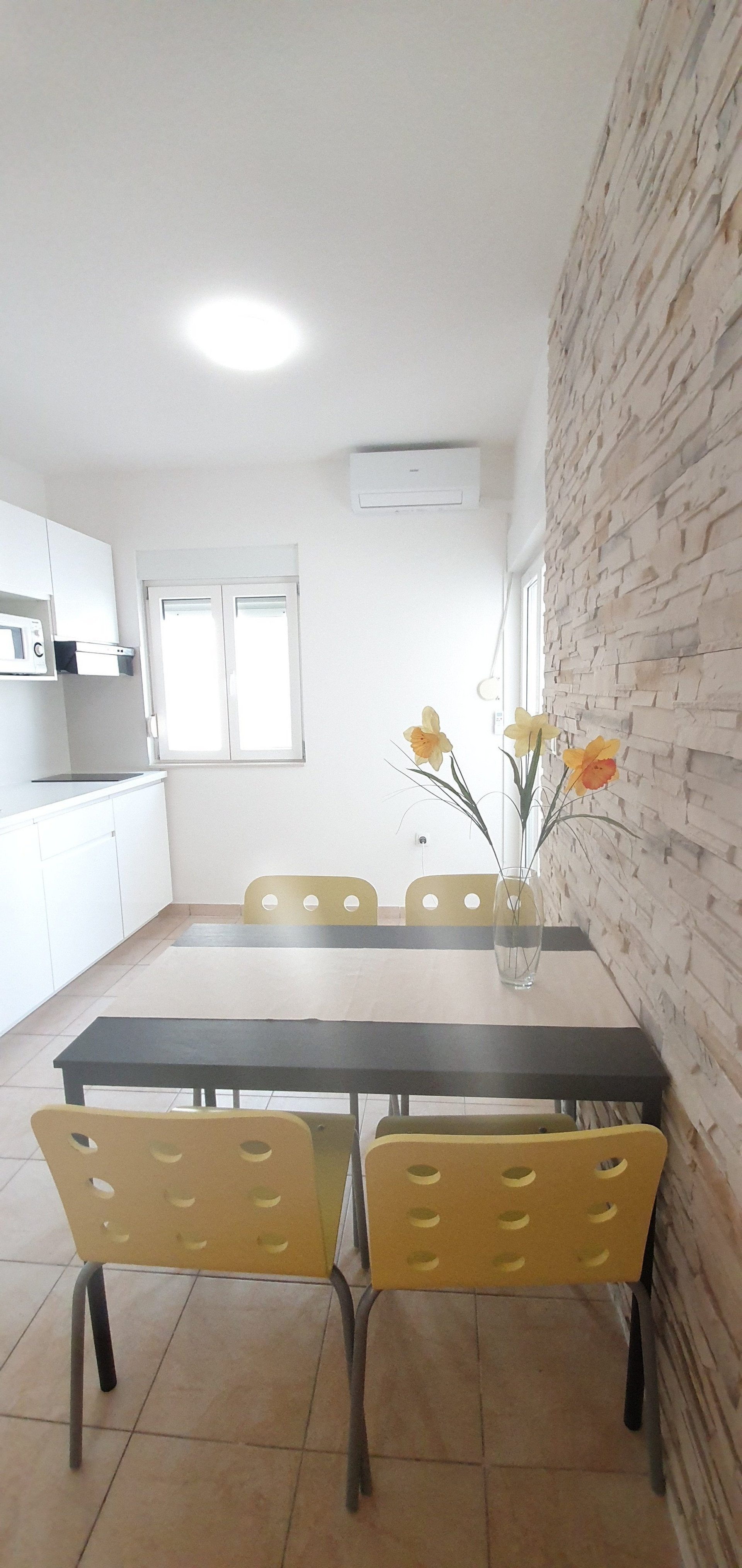 Dining area with kitchen and stone wall
