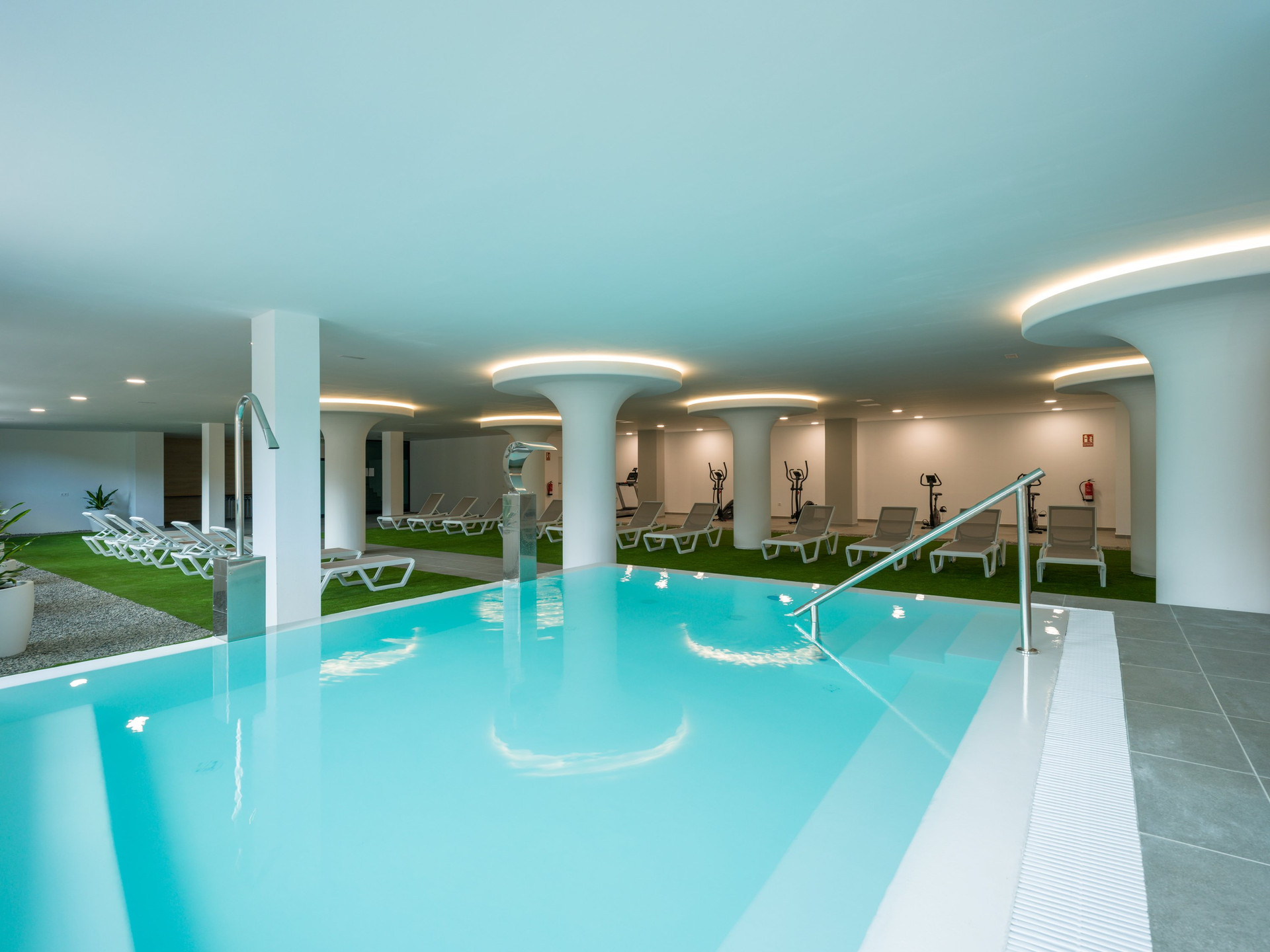 Indoor pool with loungers and gym