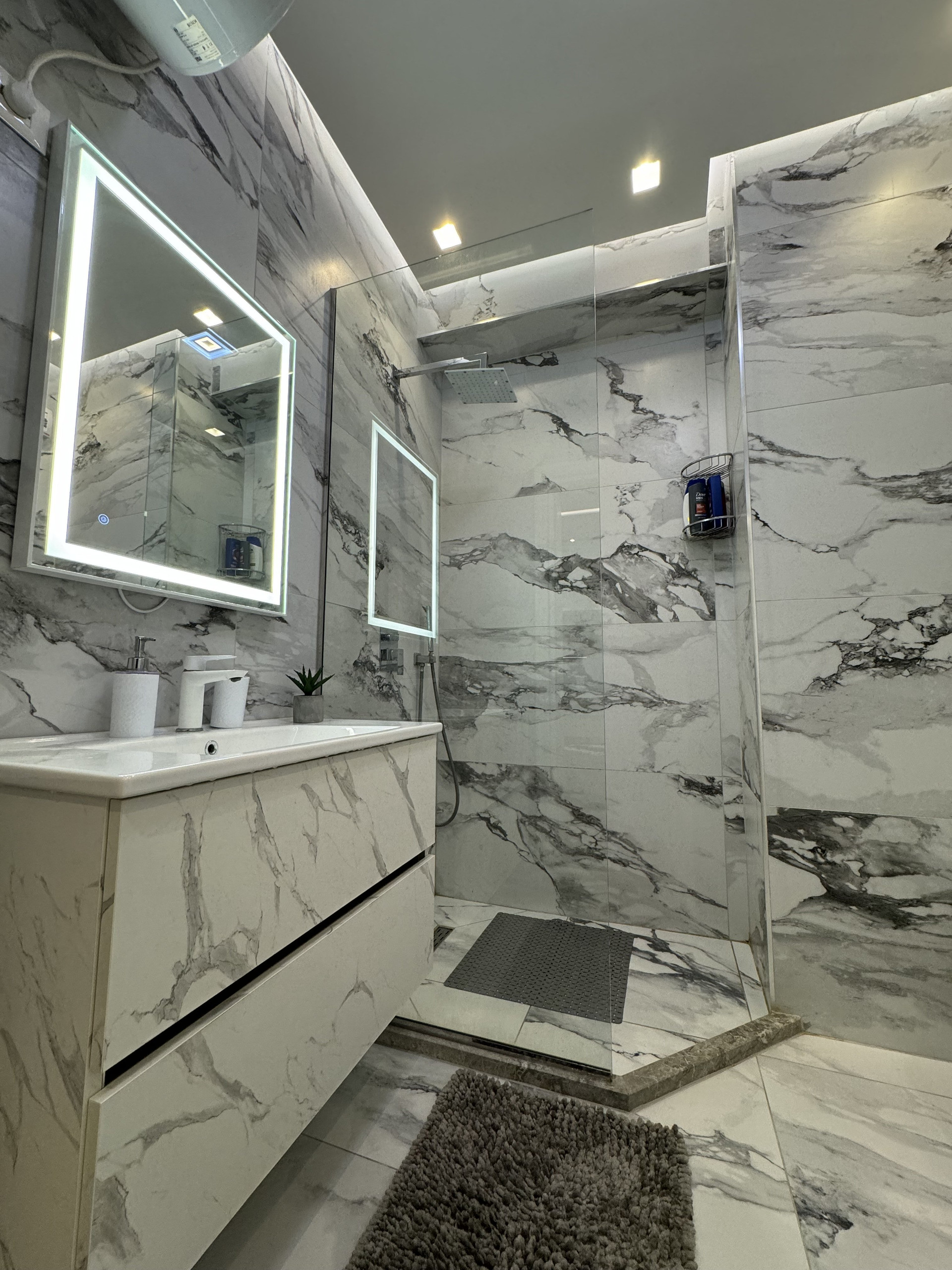 Marble bathroom with lit mirror