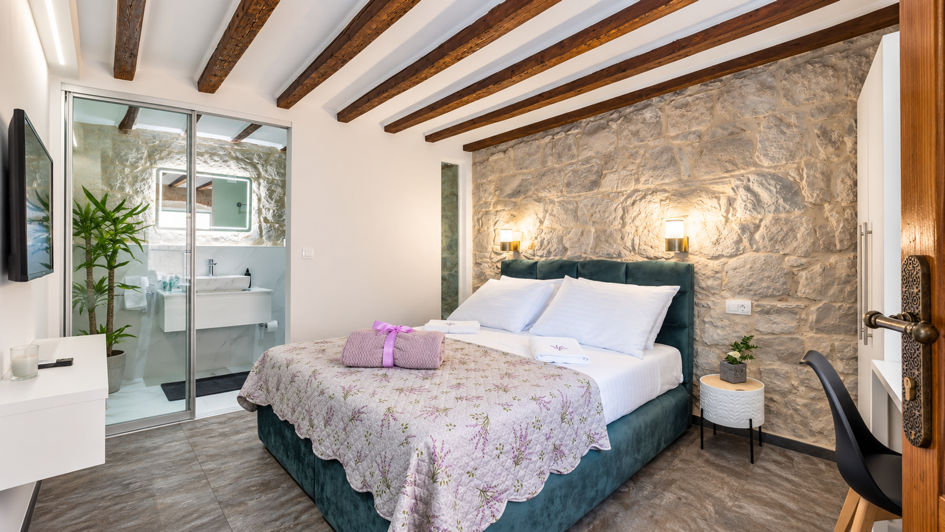 Bedroom with stone wall and bathroom