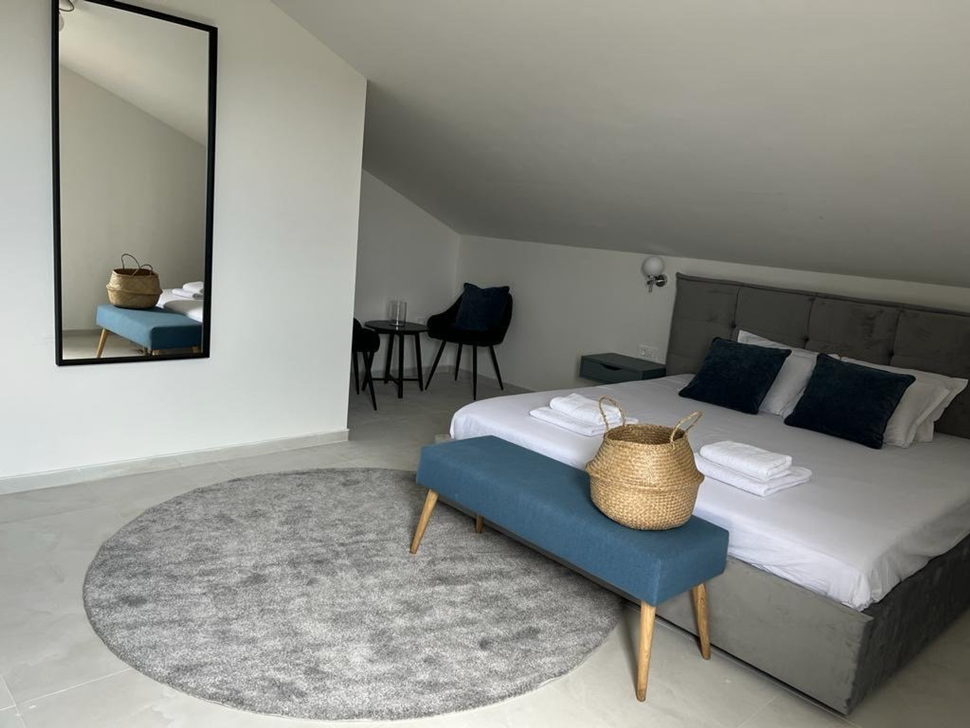 Bright bedroom with mirror and bench