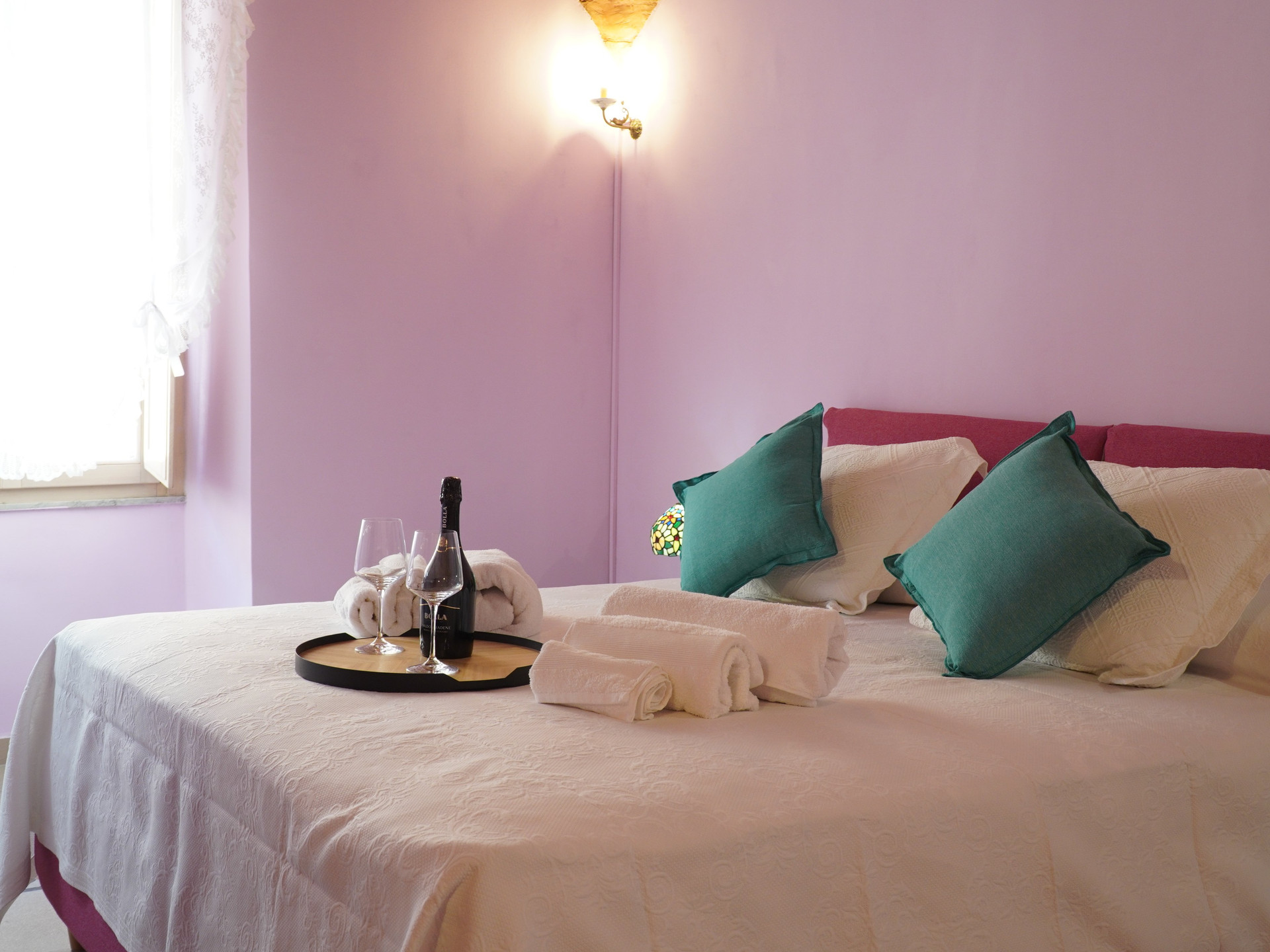 Bedroom with plush pillows, welcome tray