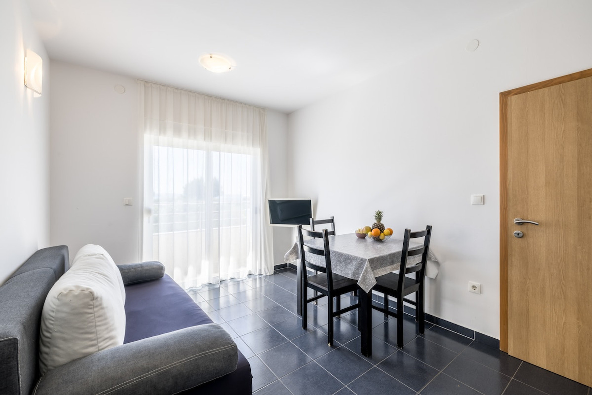 Living room with dining table and access to the balcony.