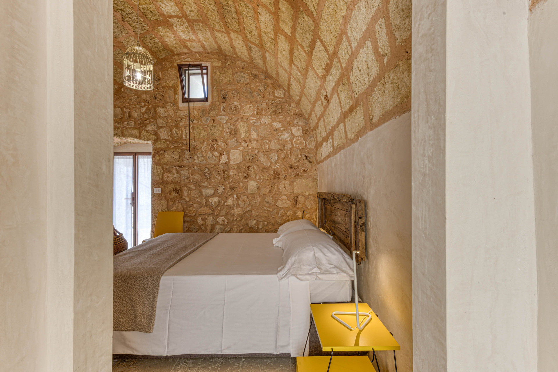 Bedroom with stone walls, yellow nightstand