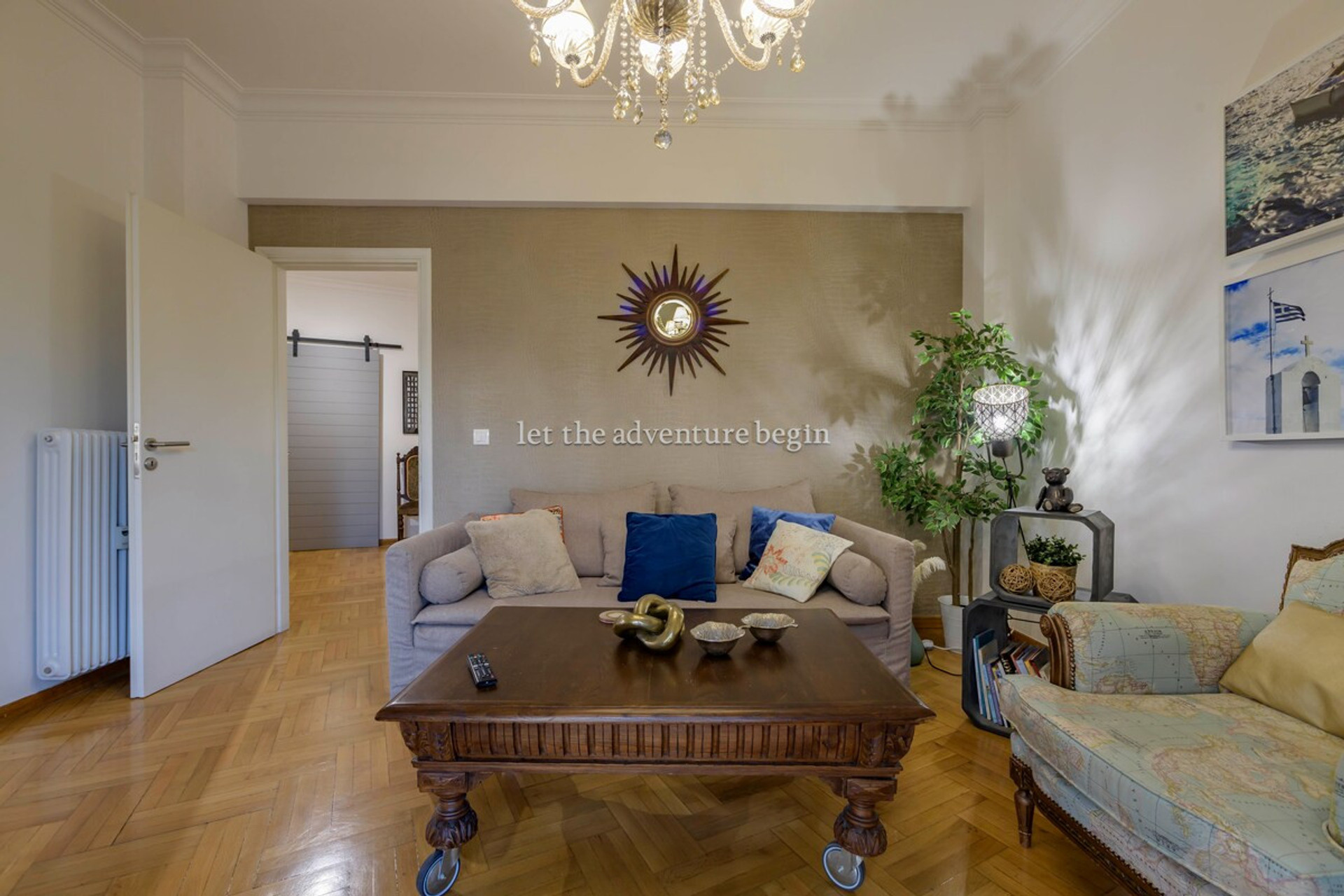 Cosy and inviting living room with elegant décor, a plush sofa, and a charming chandelier. Perfect for relaxing with a book or enjoying a film on the smart TV. A warm space to let your adventure begin!