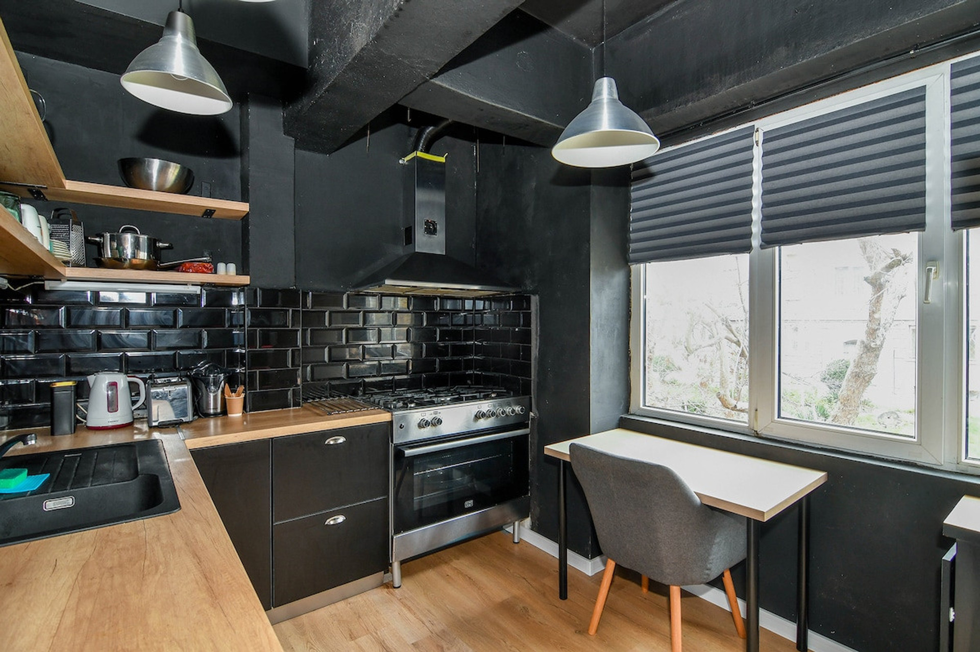 A rustic and inviting kitchen, designed with an industrial touch, featuring open shelving, modern appliances, and stylish lighting to enhance your cooking experience.
