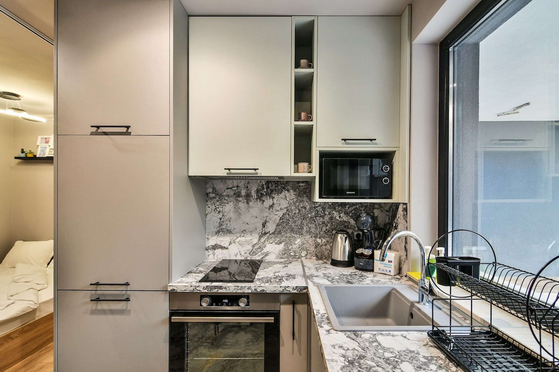 High-end kitchen setup with a marble countertop, built-in microwave, stainless steel sink, and essential cookware. The ideal space for preparing meals during your stay