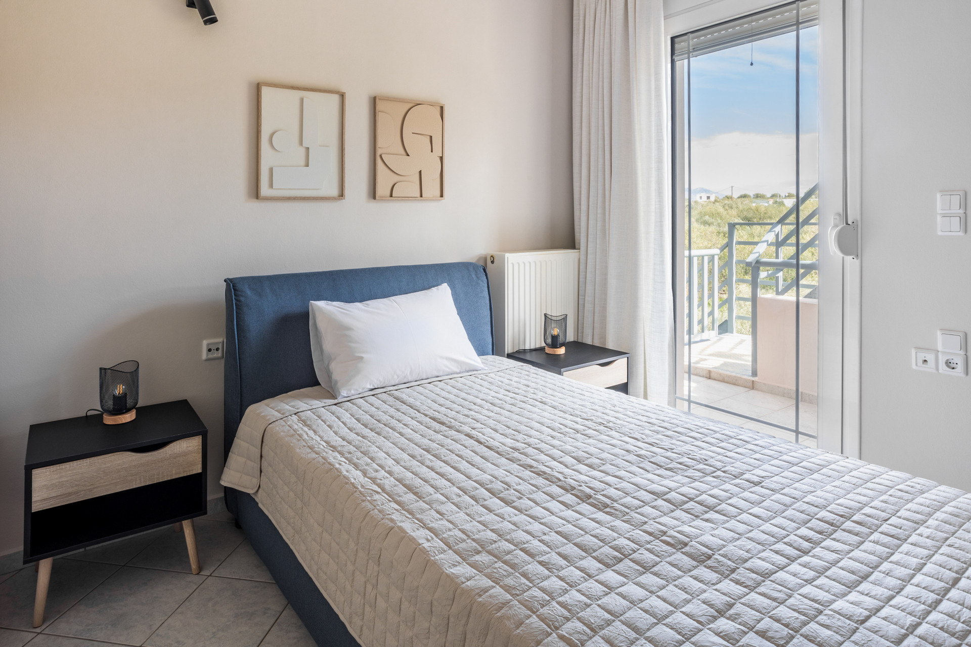 Cozy single bedroom with bedside table, chair, and window overlooking the surroundings