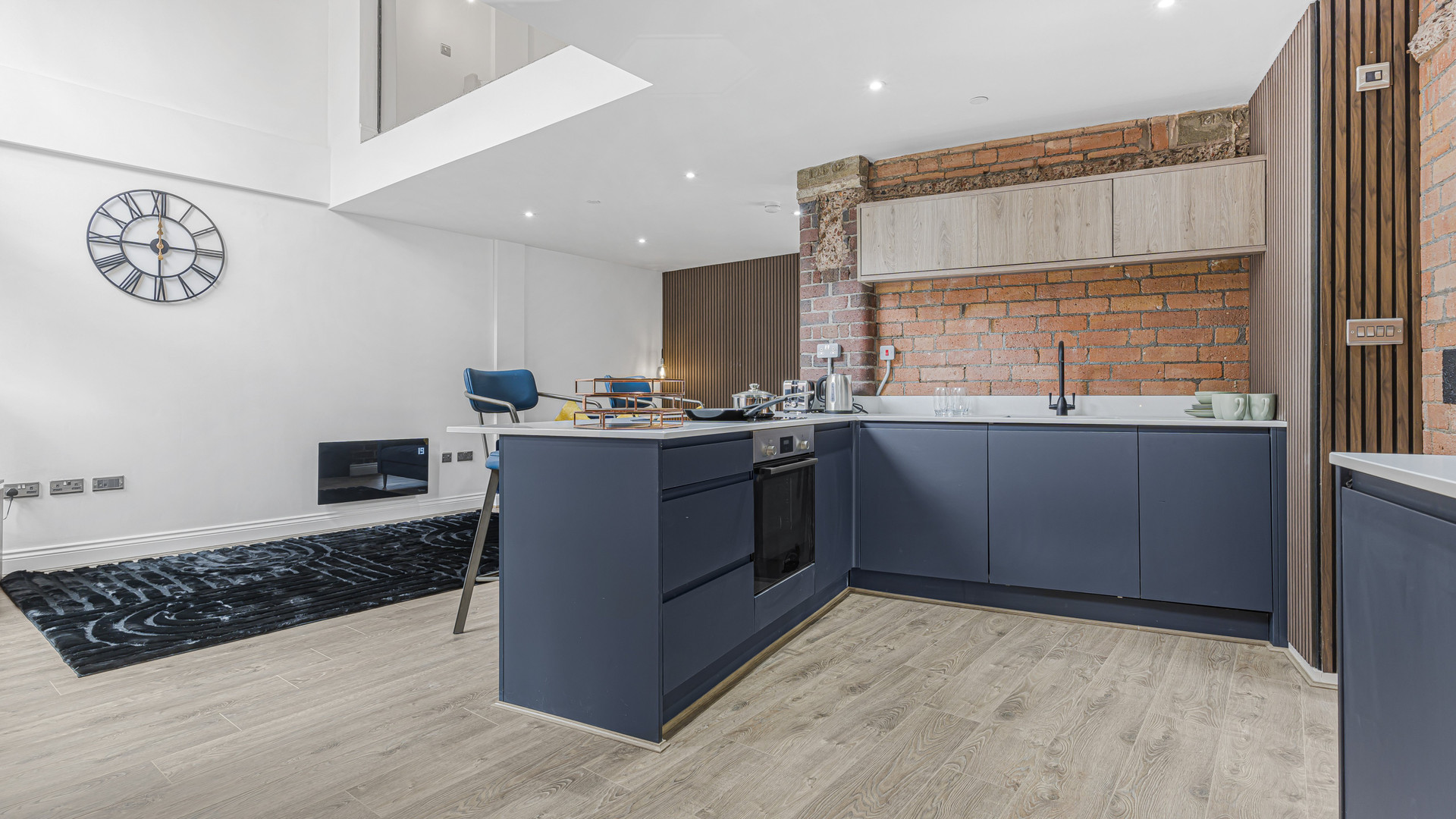 Modern blue kitchen with brick wall