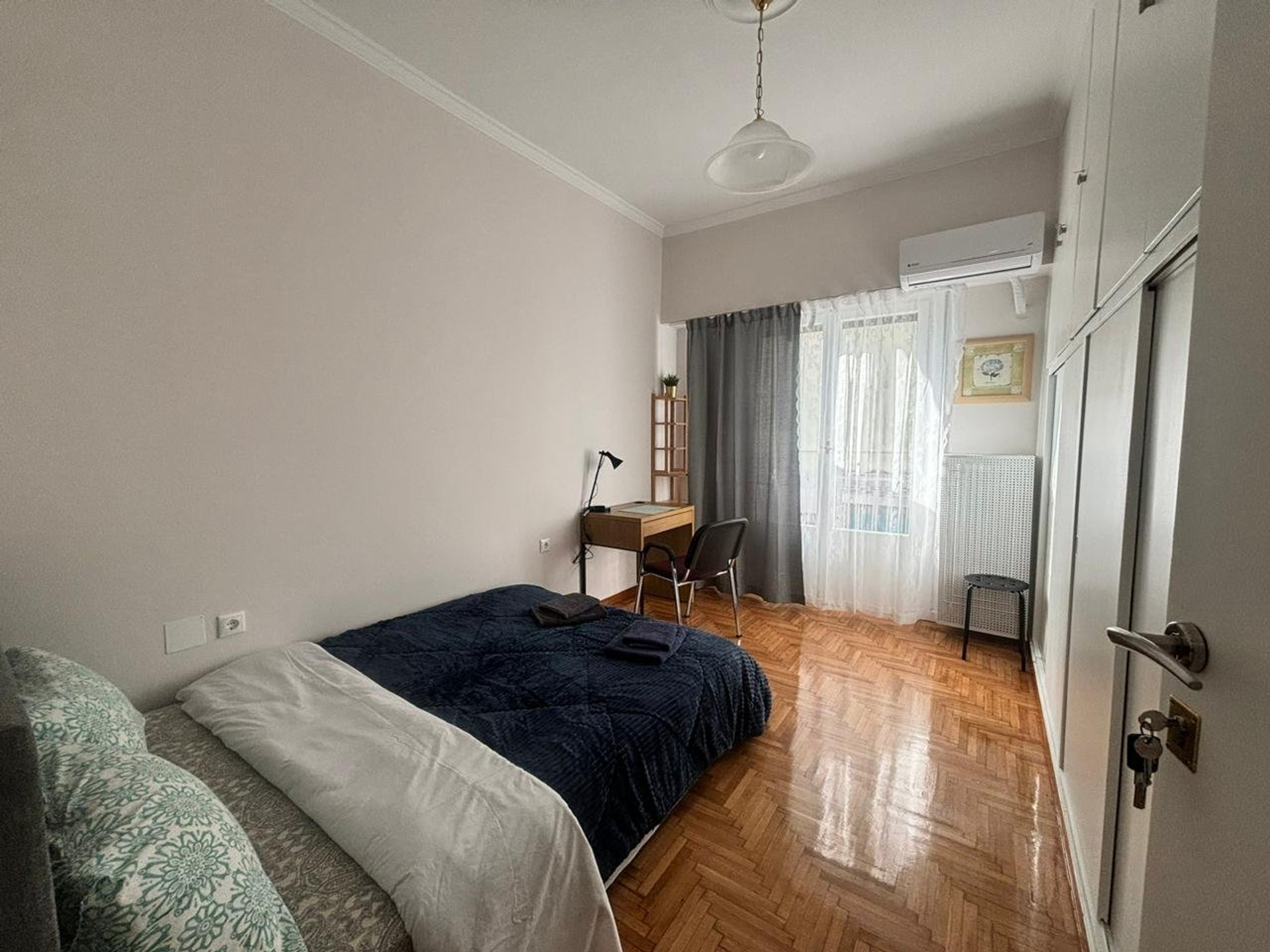 Bright bedroom with desk and wardrobe