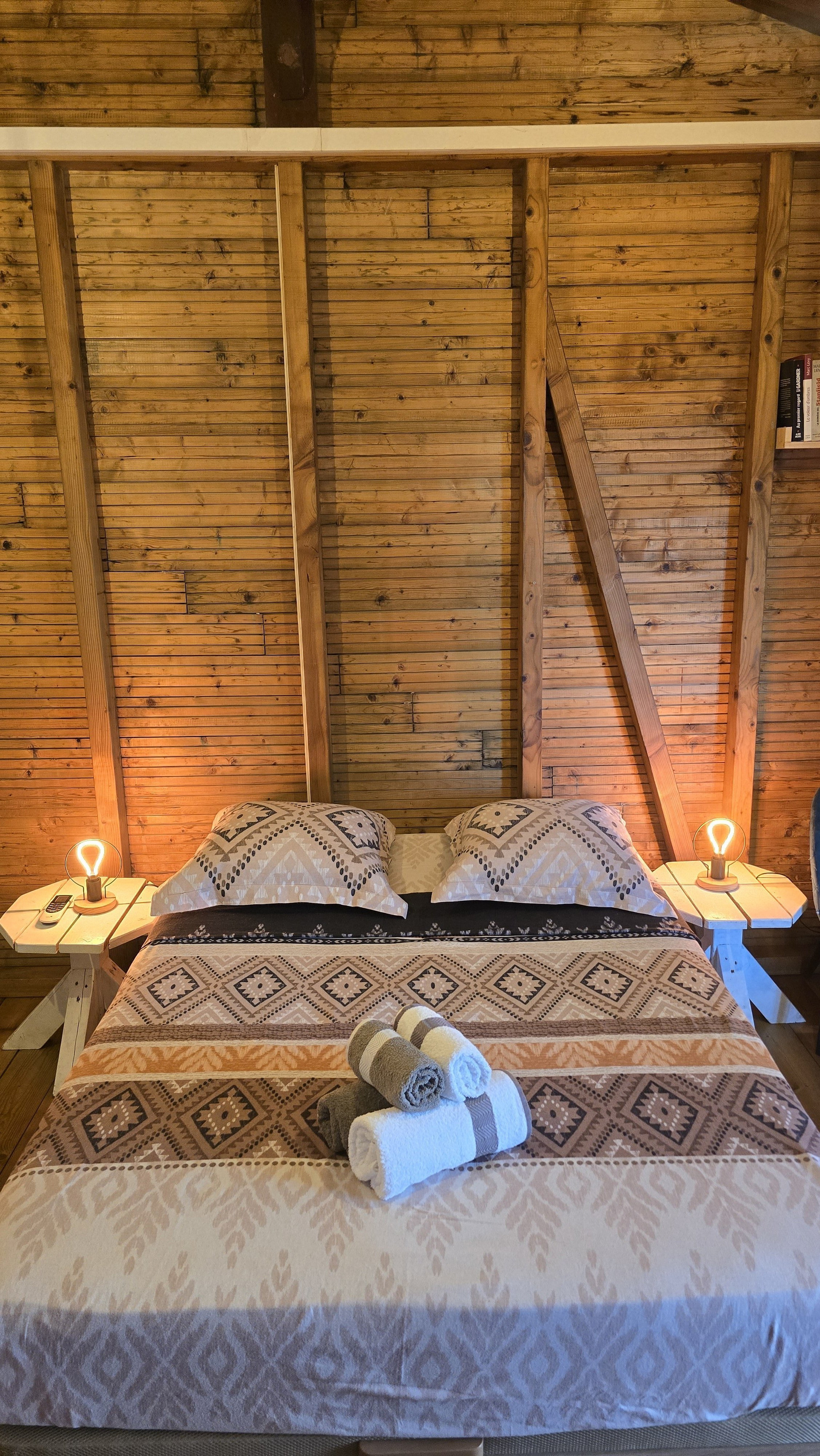 Comfortable double bed with soft lighting in a cozy wooden interior