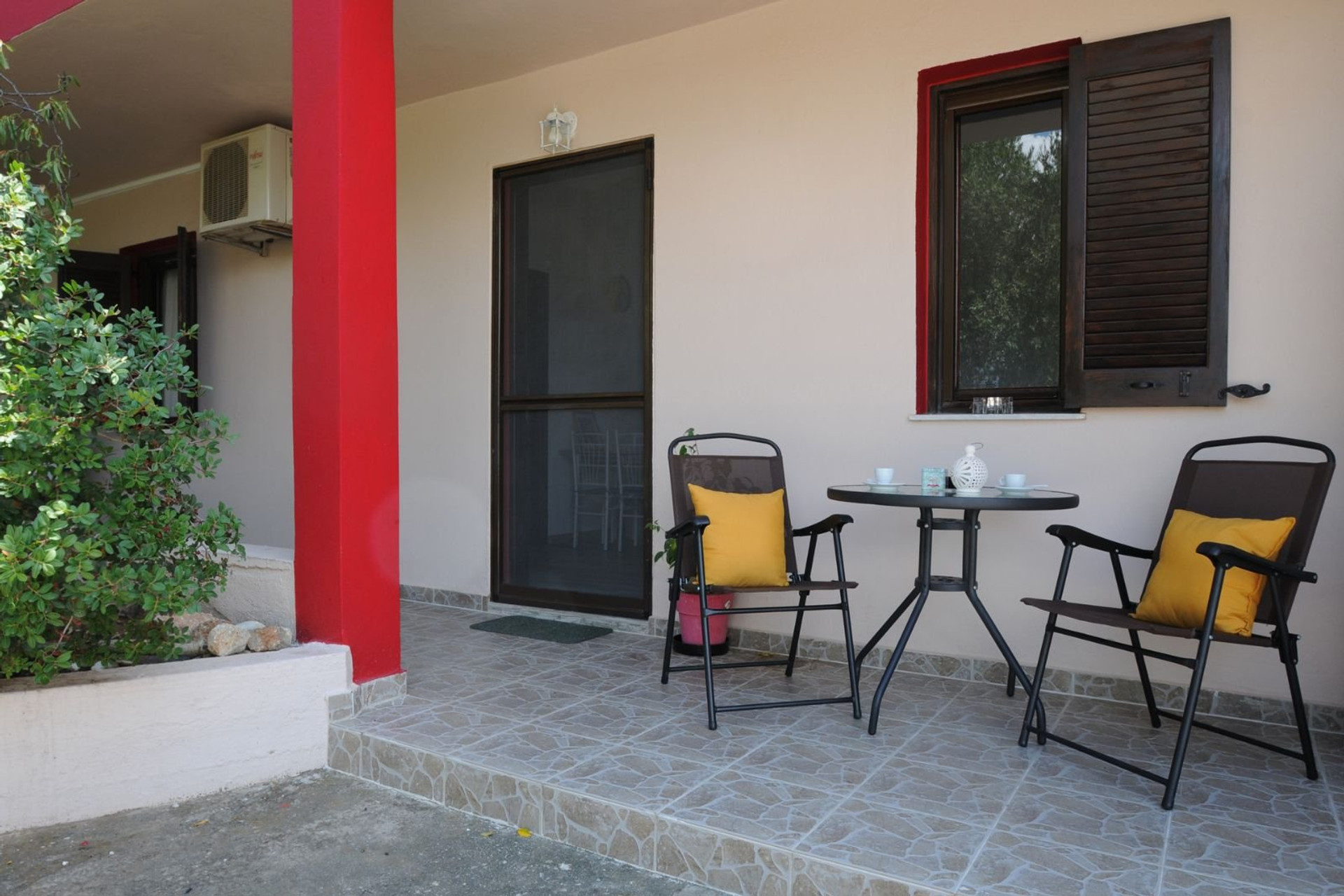 A cozy outdoor patio with seating, ideal for enjoying a morning coffee or relaxing in a quiet, private setting.