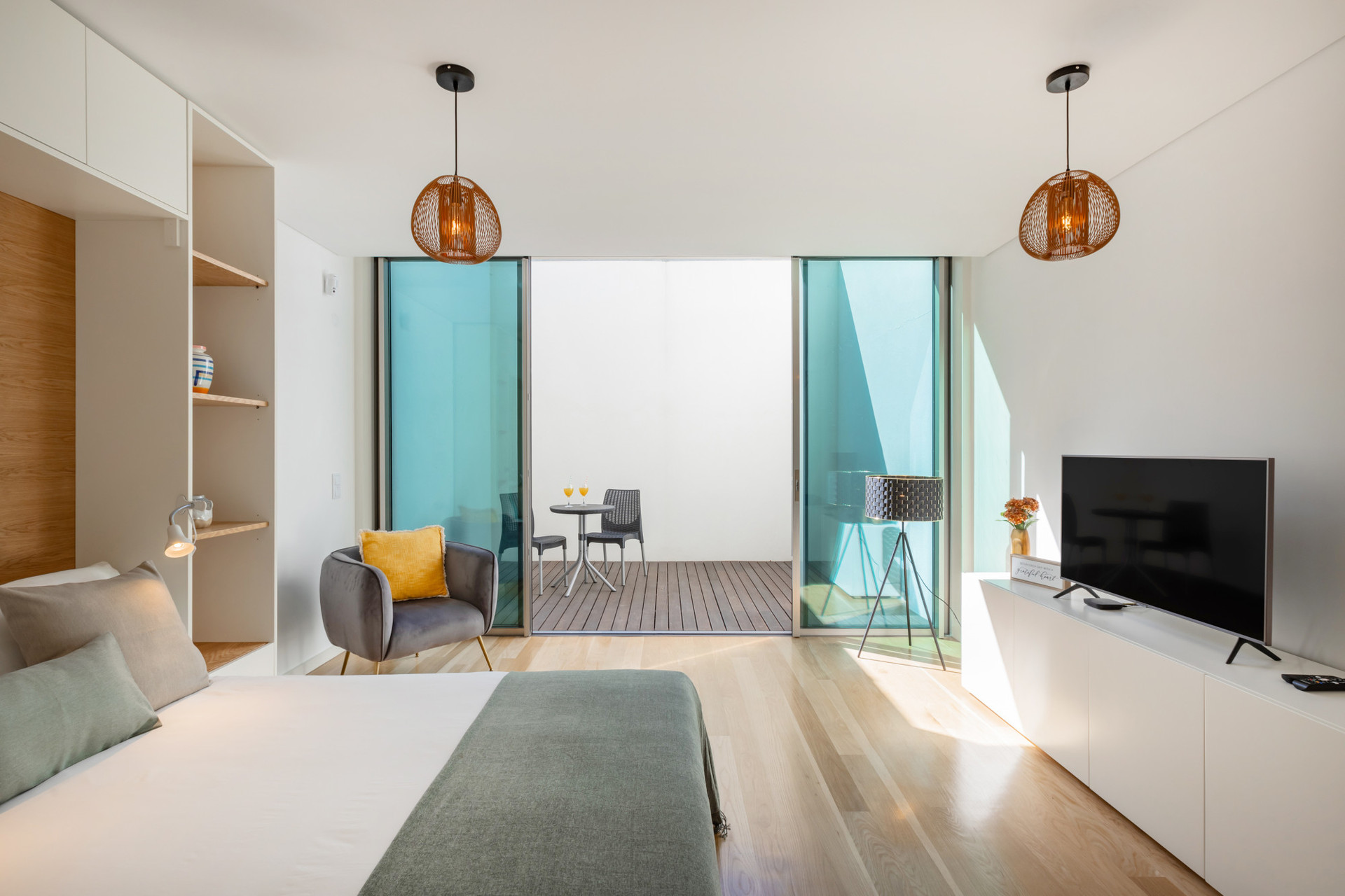 Living Area with a murphy bed (folding to the wall) and TV that opens onto a private interior patio.