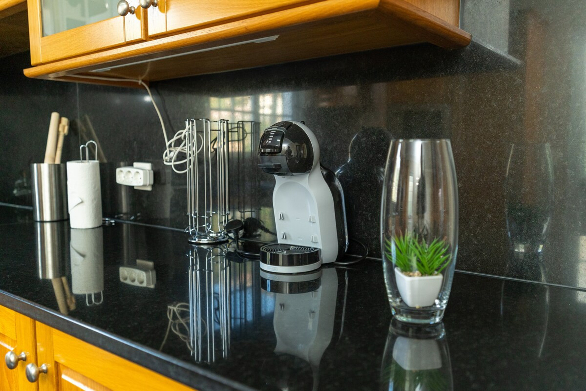 Kitchen counter with coffee machine, simple utensils and minimalist decoration. Clean, modern and functional surface, creating a practical and elegant environment.