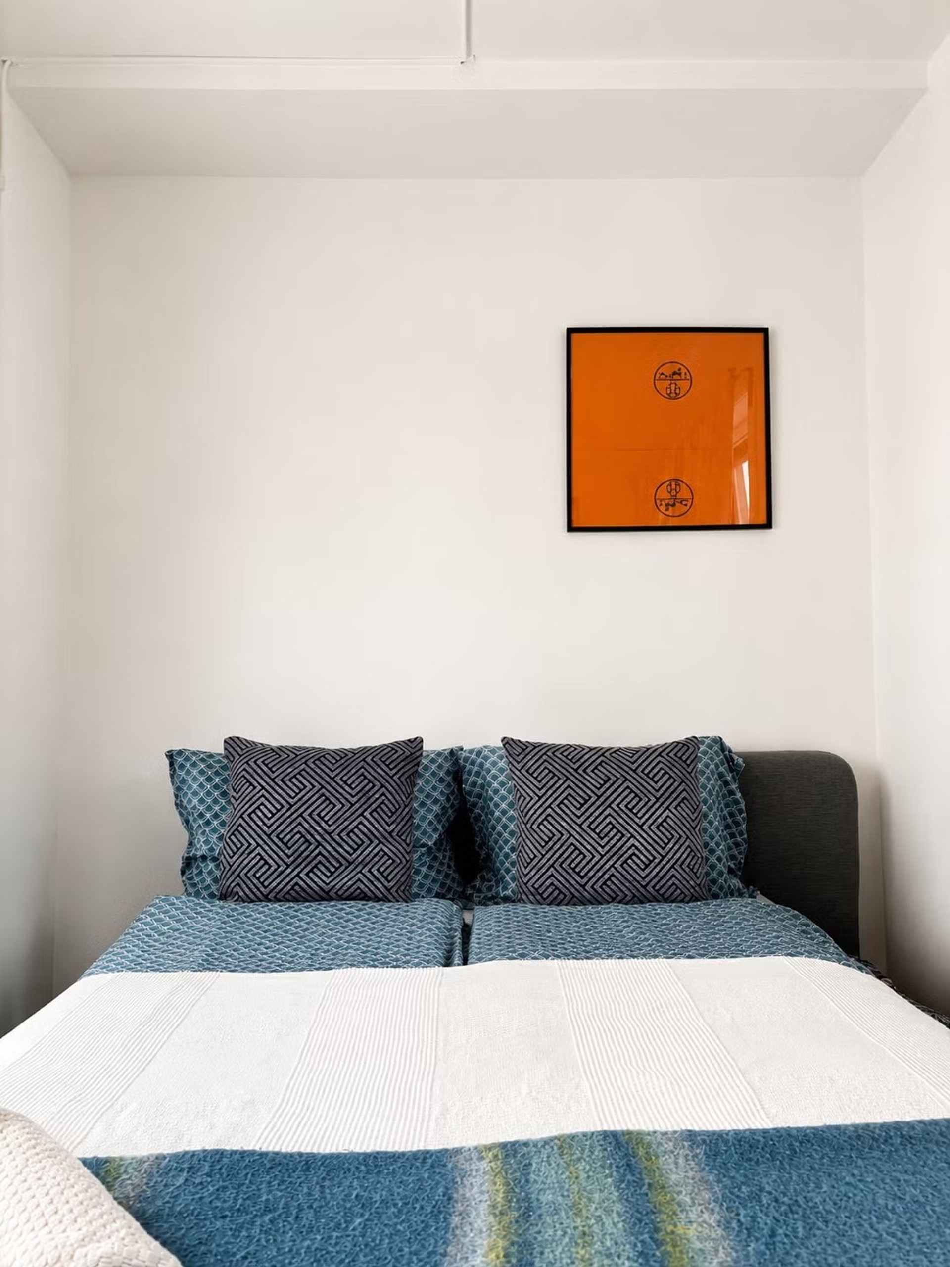 Double bed with orange artwork