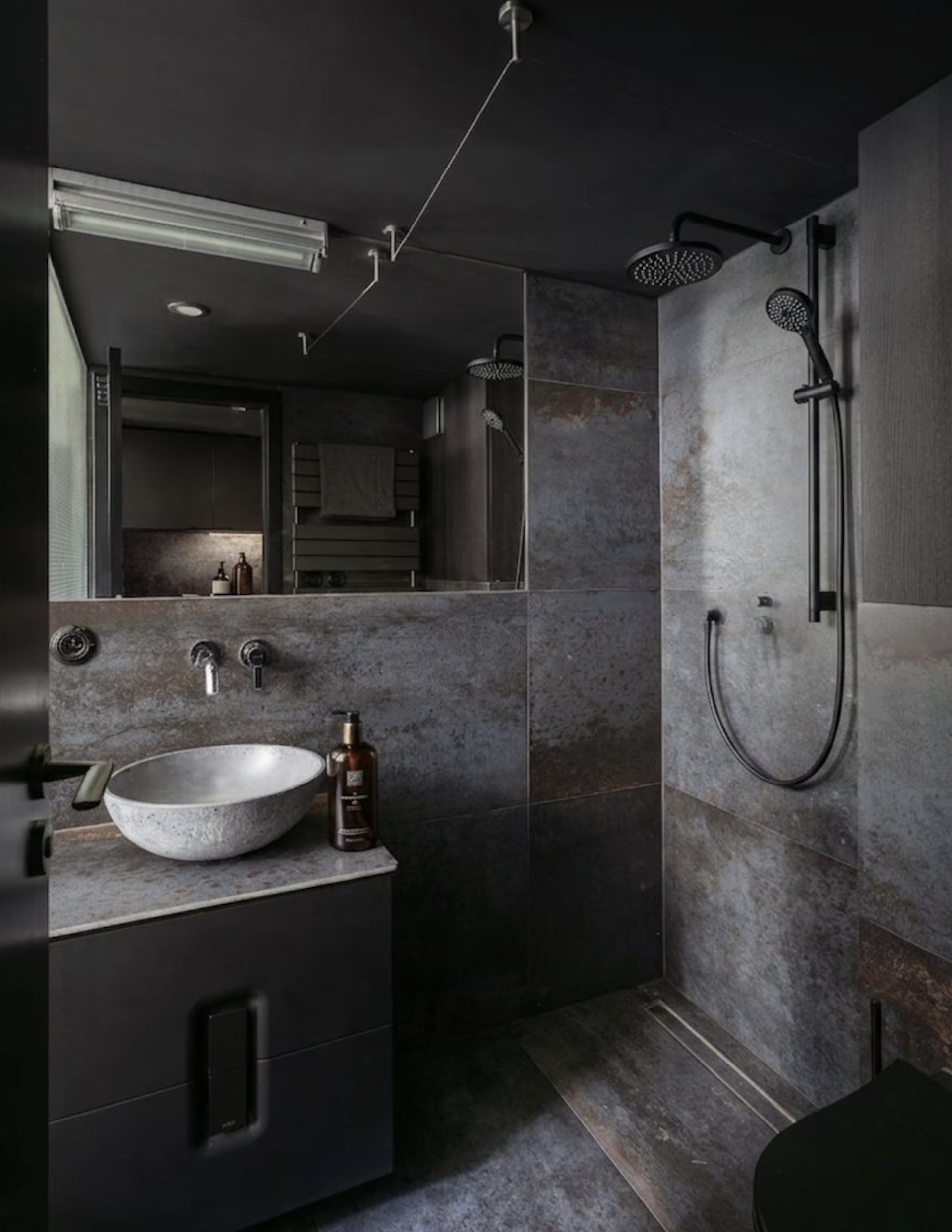Dark tiled bathroom with shower