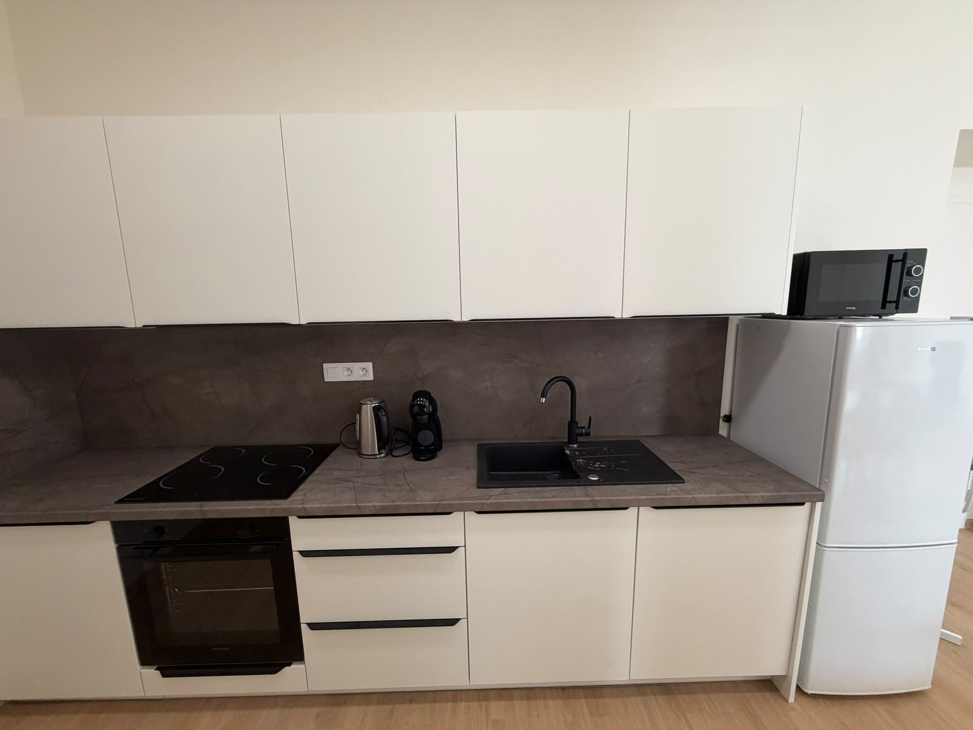 Kitchen with cooktop and fridge