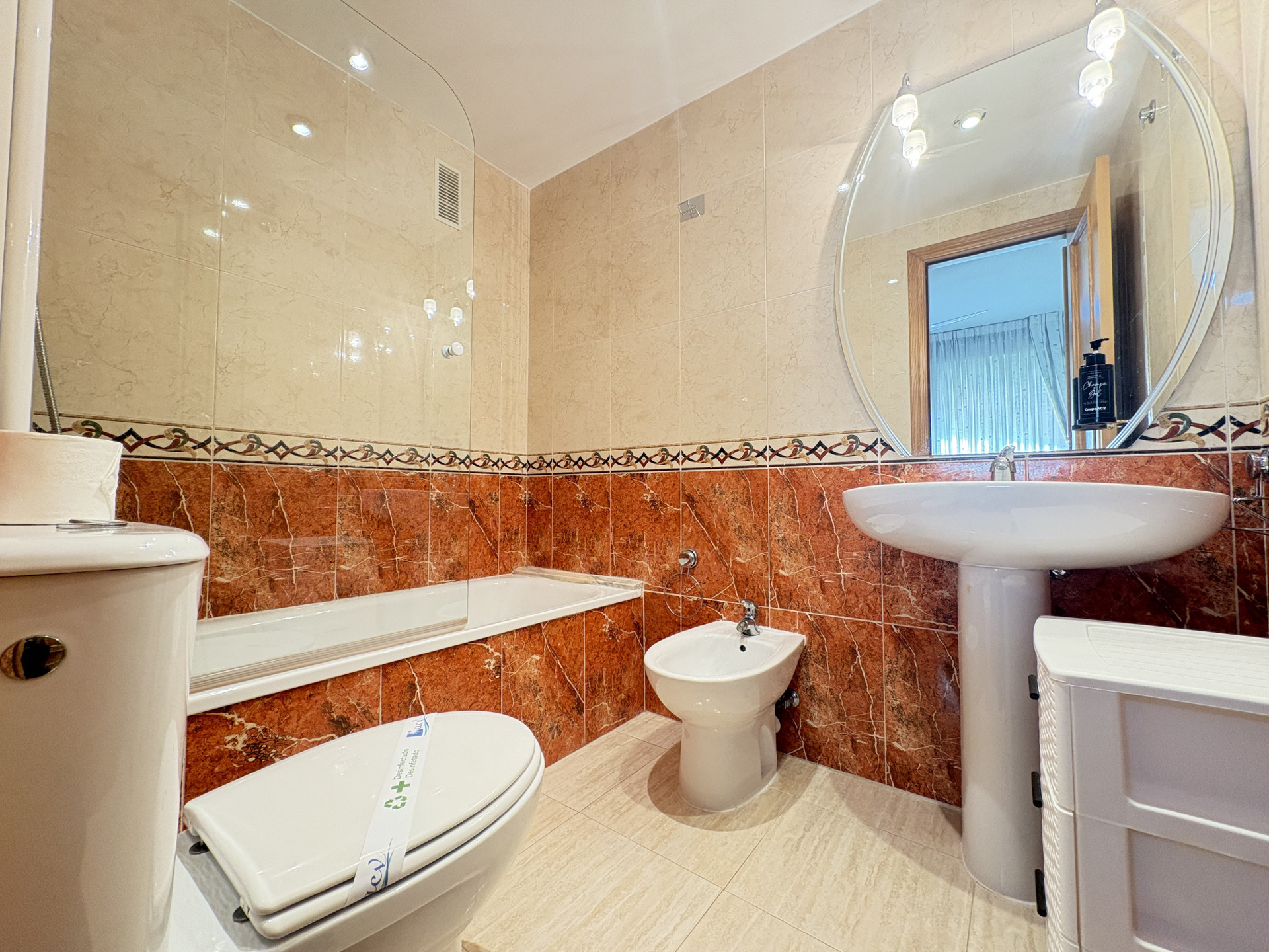 Bathroom with bathtub and round mirror