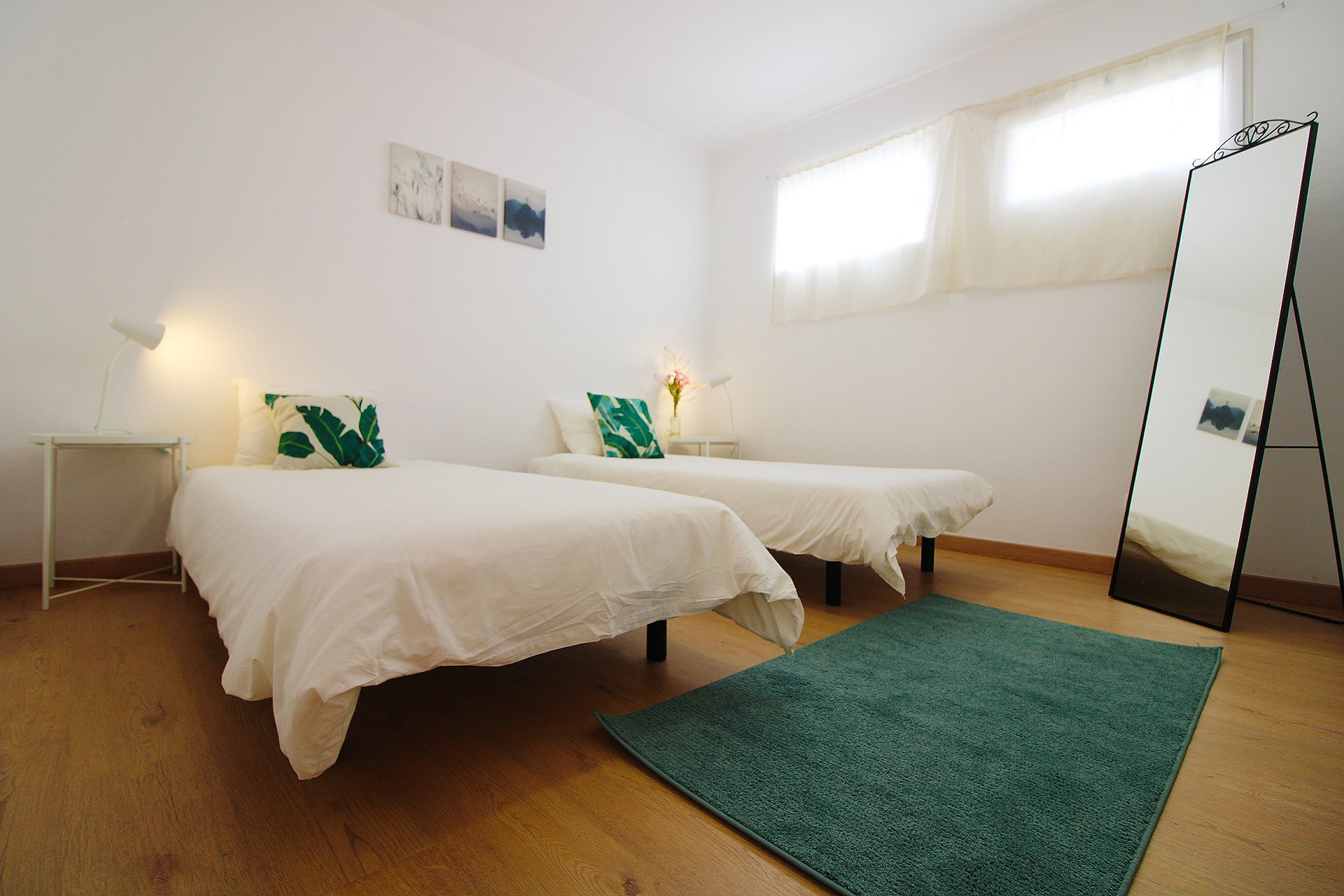 Twin bedroom with mirror and rug