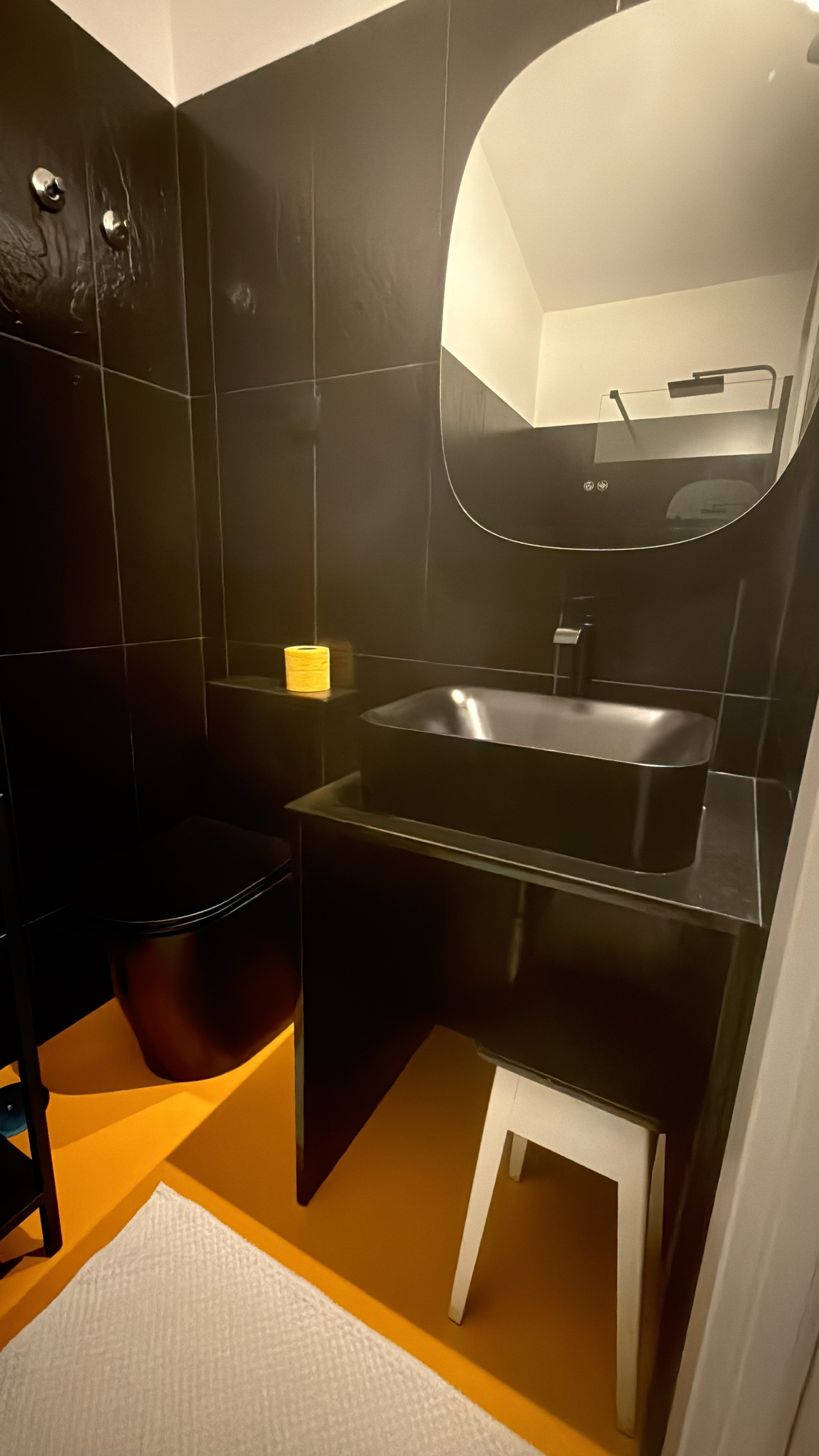 Bathroom with black tiles and mirror