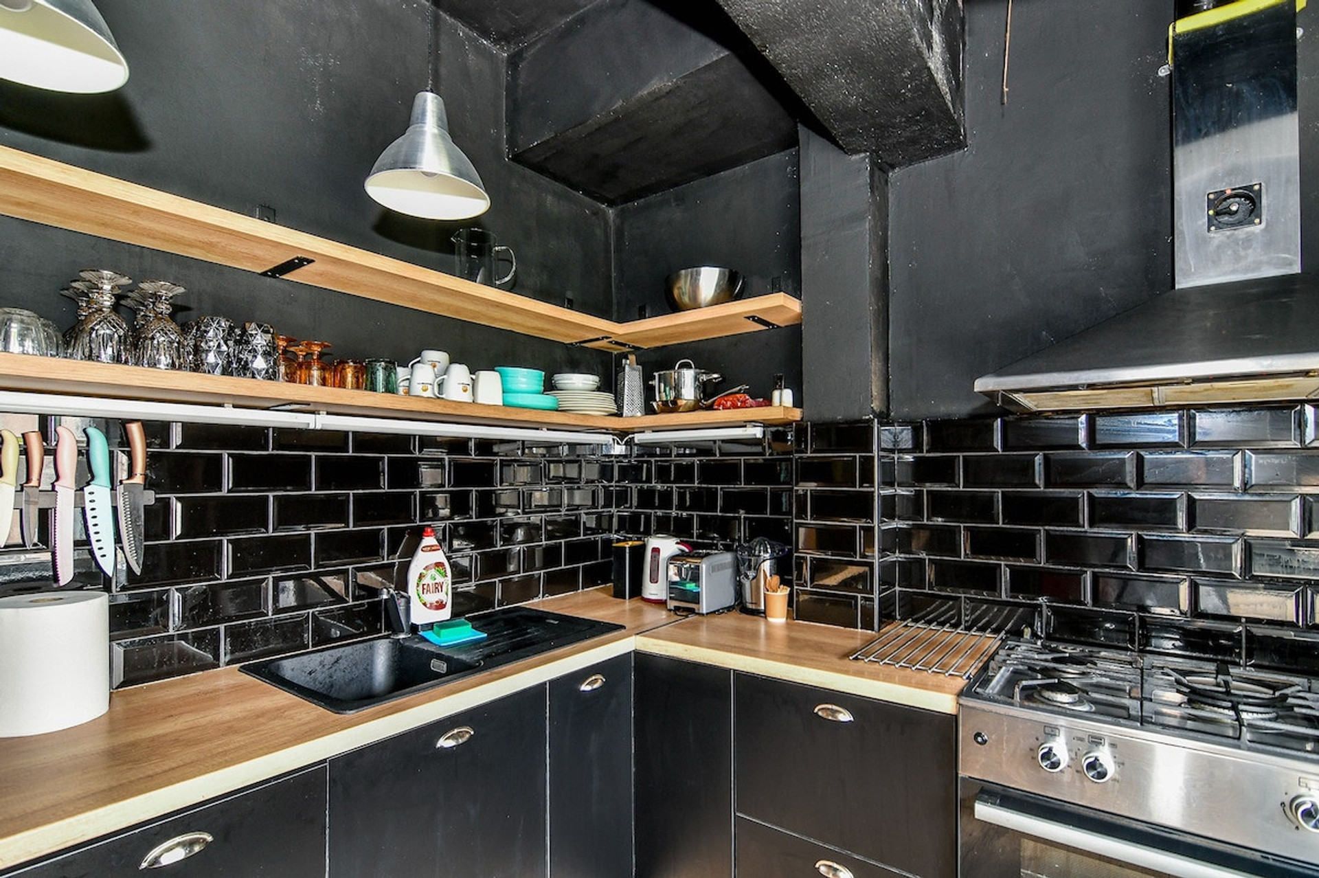 Another perspective of the kitchen, emphasizing its spacious layout and modern appliances, including a gas stove, oven, and essential kitchenware.