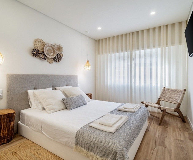 Bright bedroom with armchair and curtains