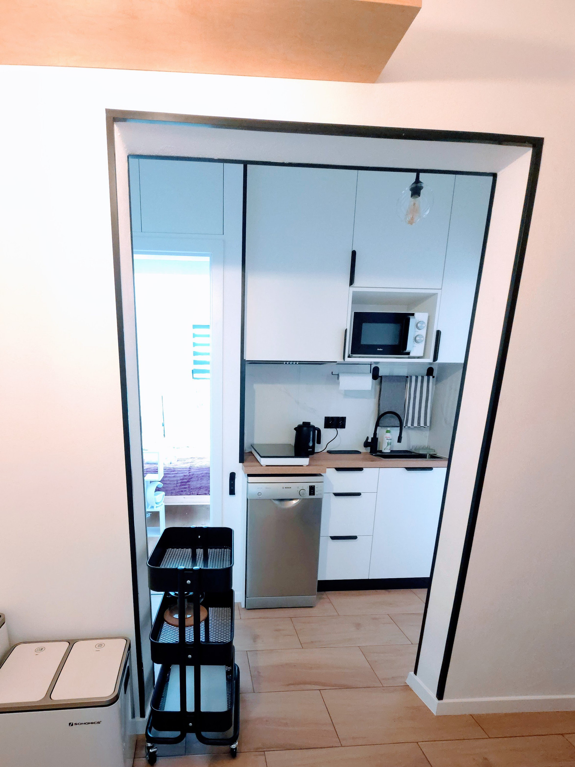 Compact white kitchen through doorway