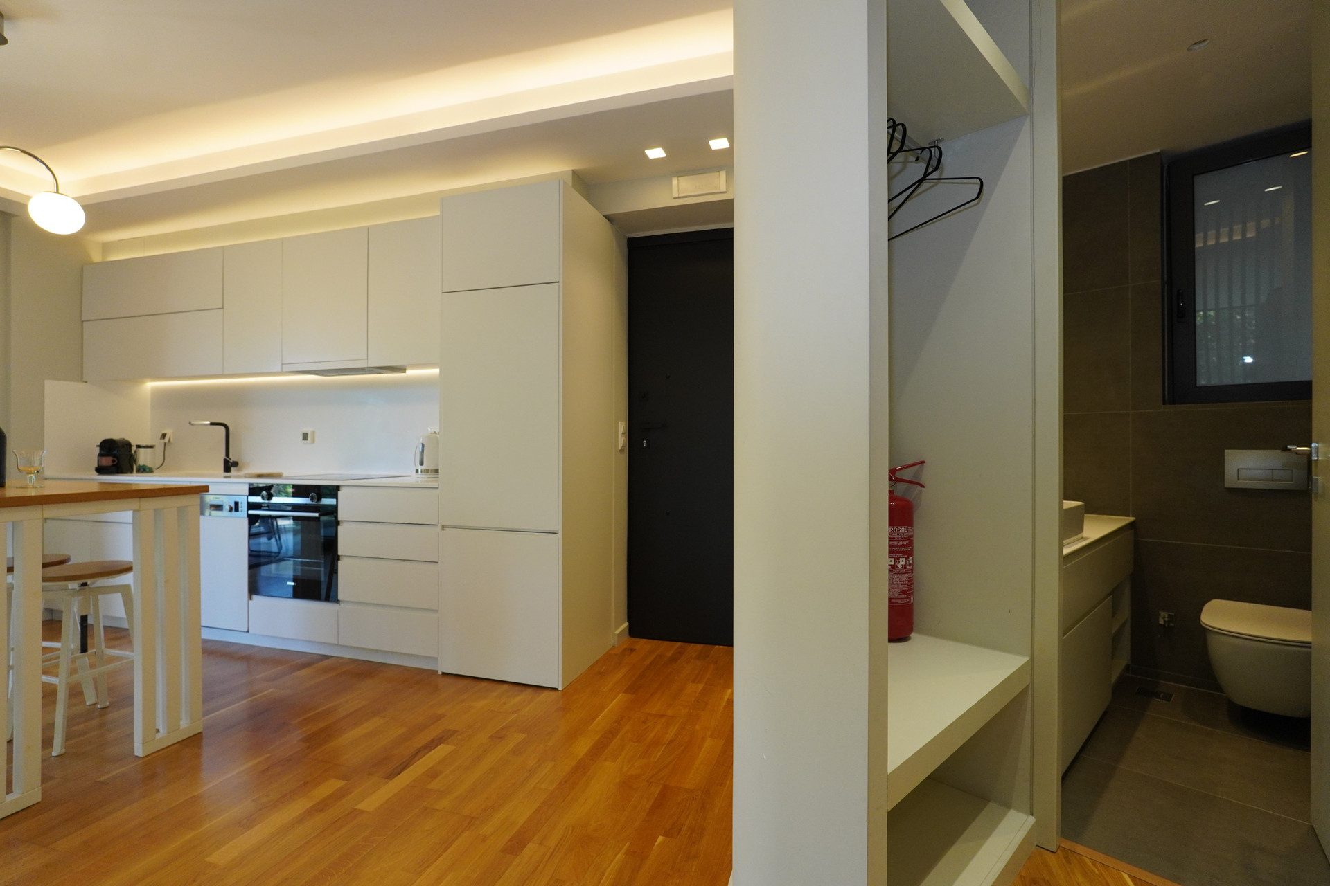 White kitchen with bathroom glimpse