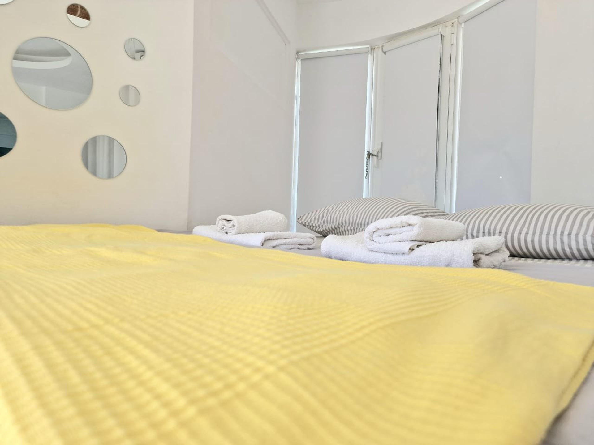 Bedroom with yellow bedcover and mirrors