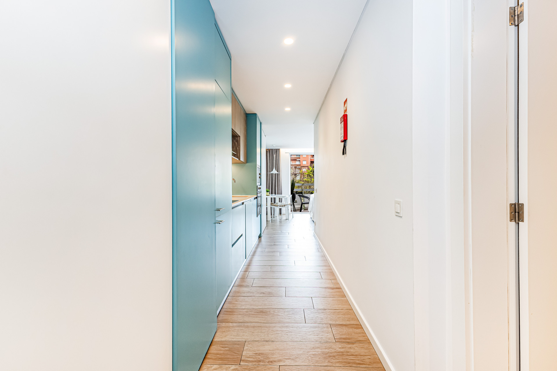 Bright hallway with blue kitchen