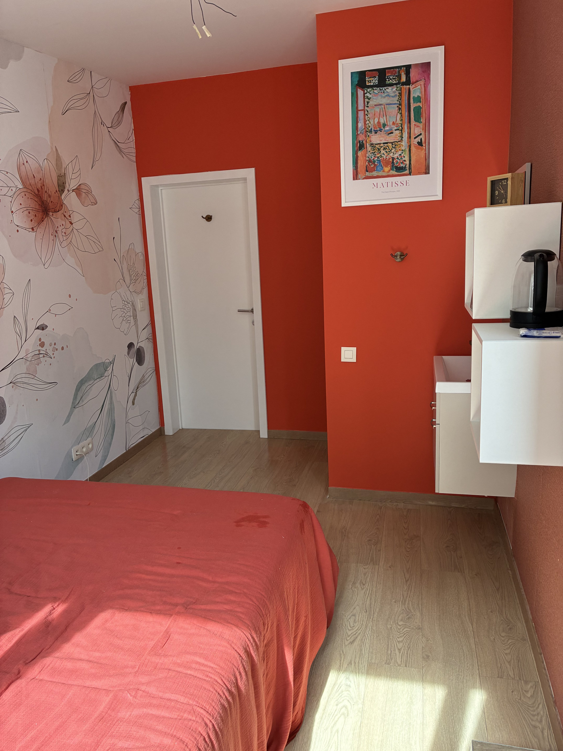 Bedroom with floral wallpaper red accents