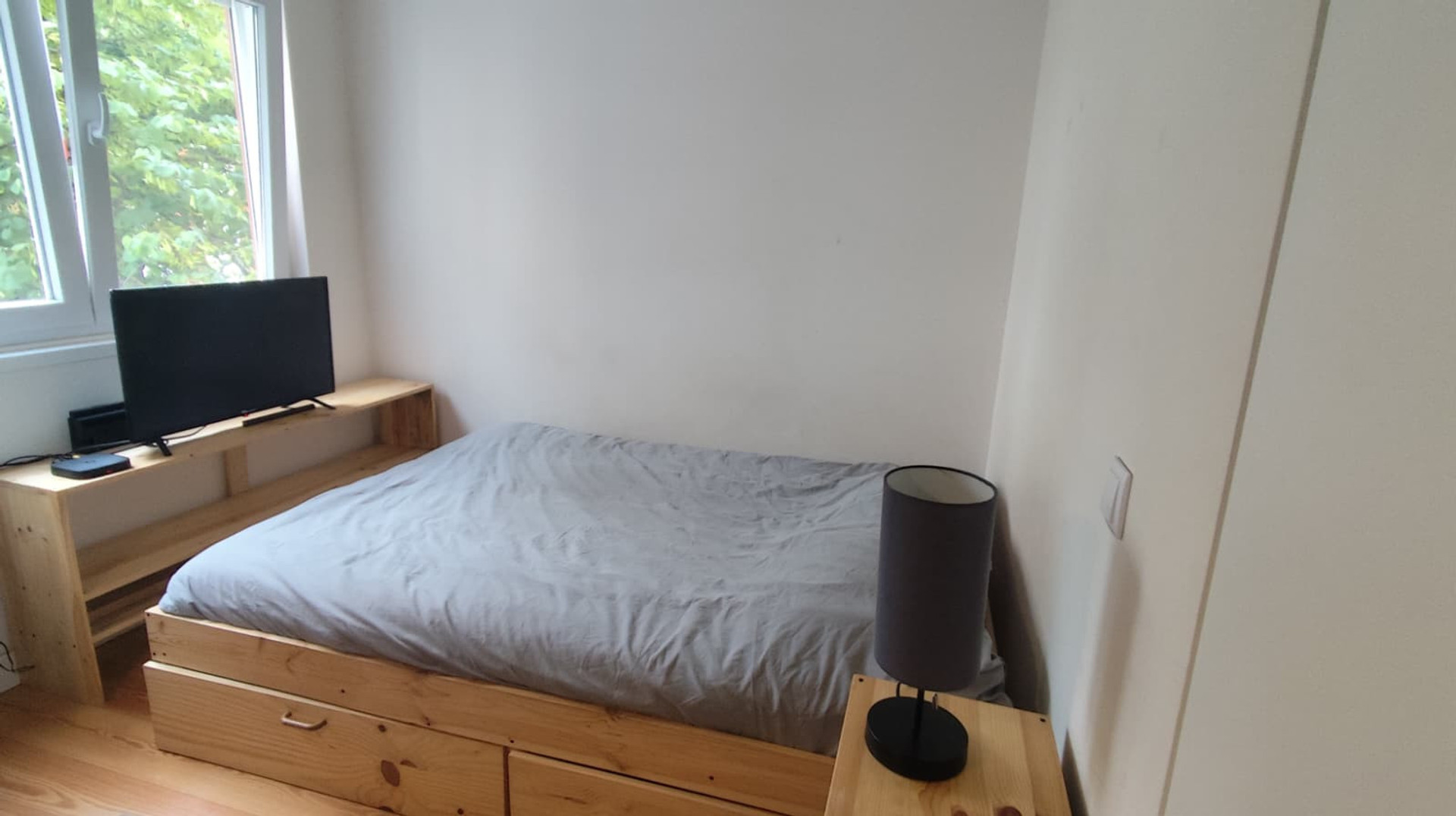 Bedroom with wooden bed and TV