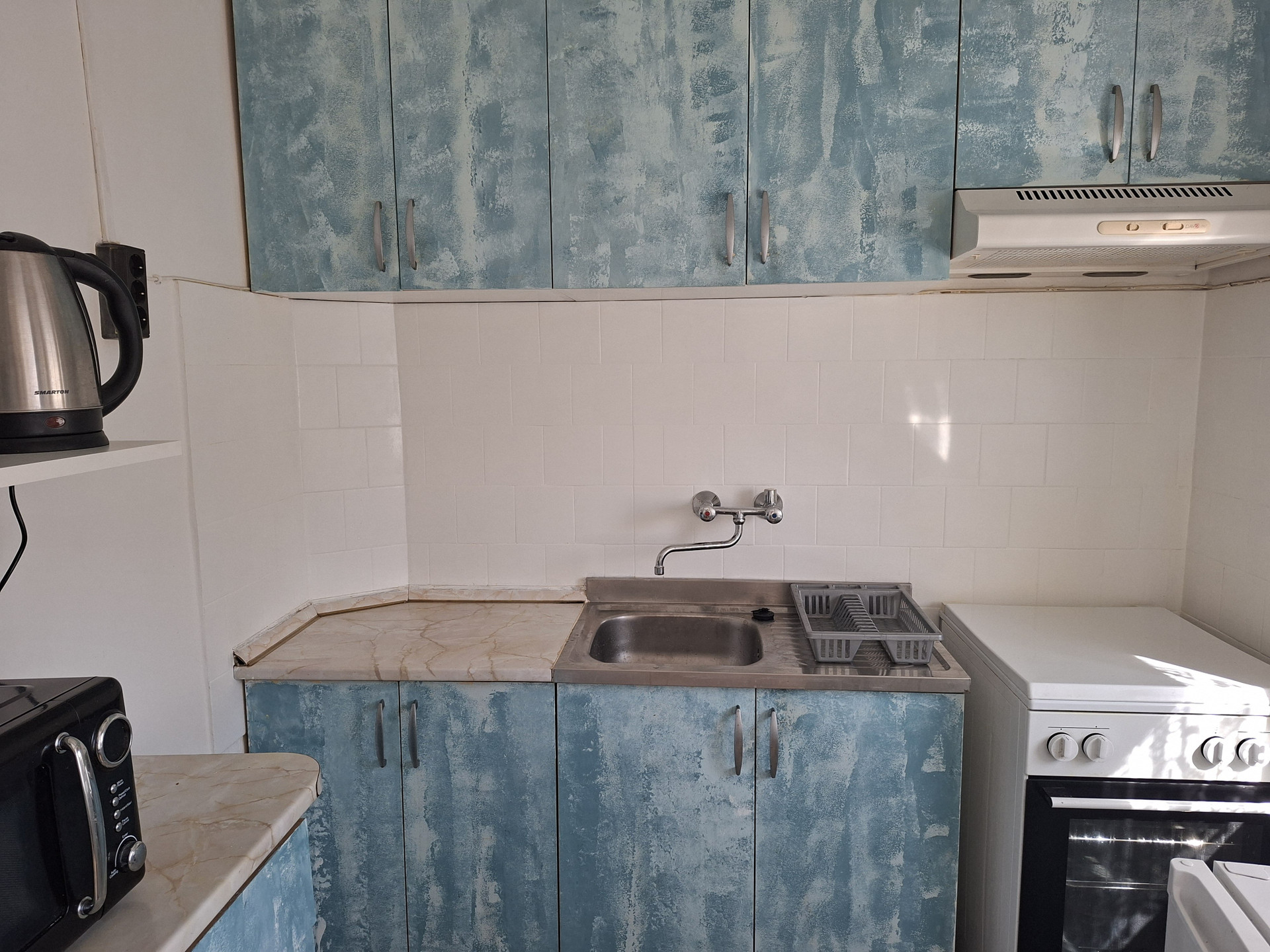 Compact kitchen with blue cabinets