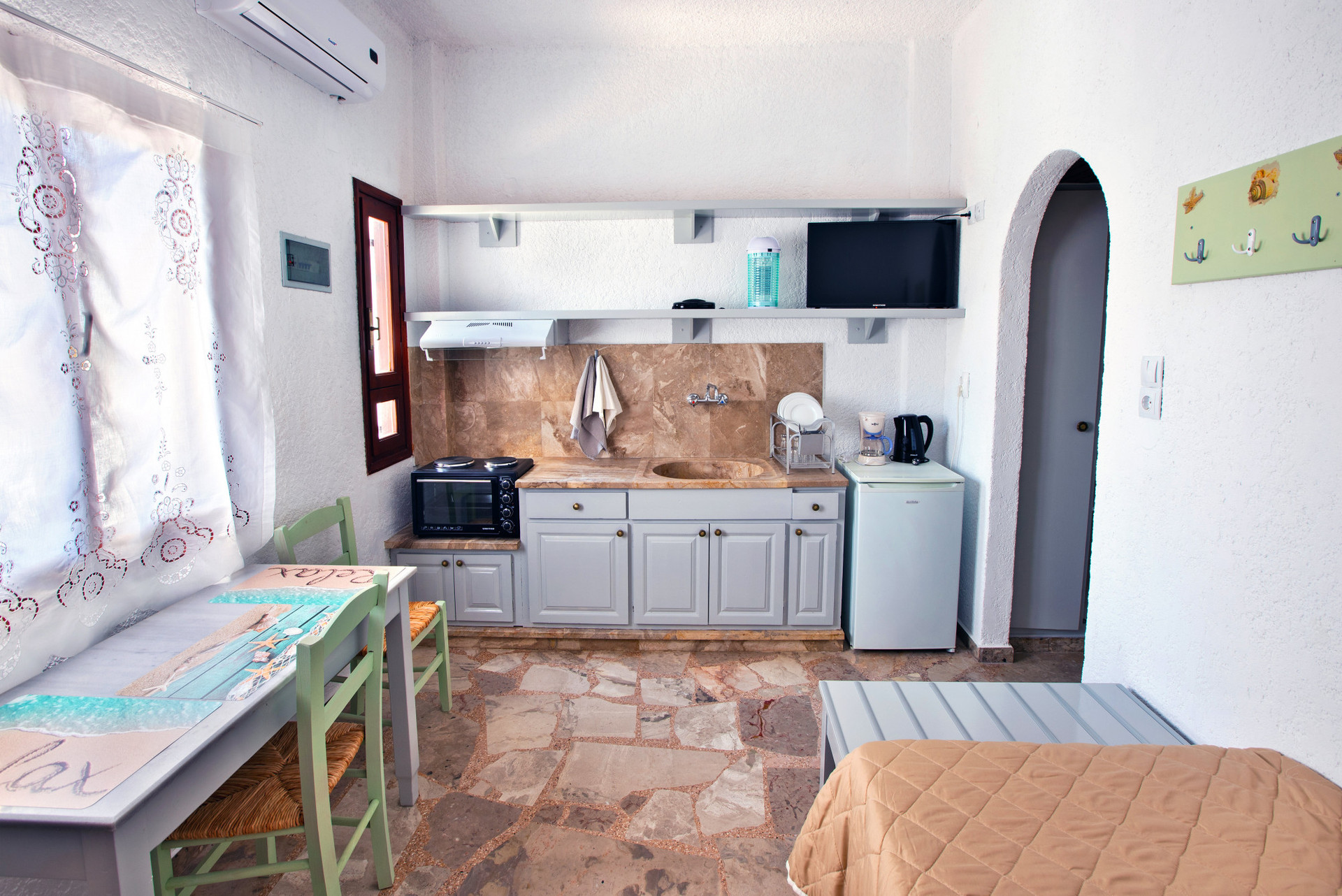 View of the living room, kitchenette, sofa bed and tabed with chairs with a view