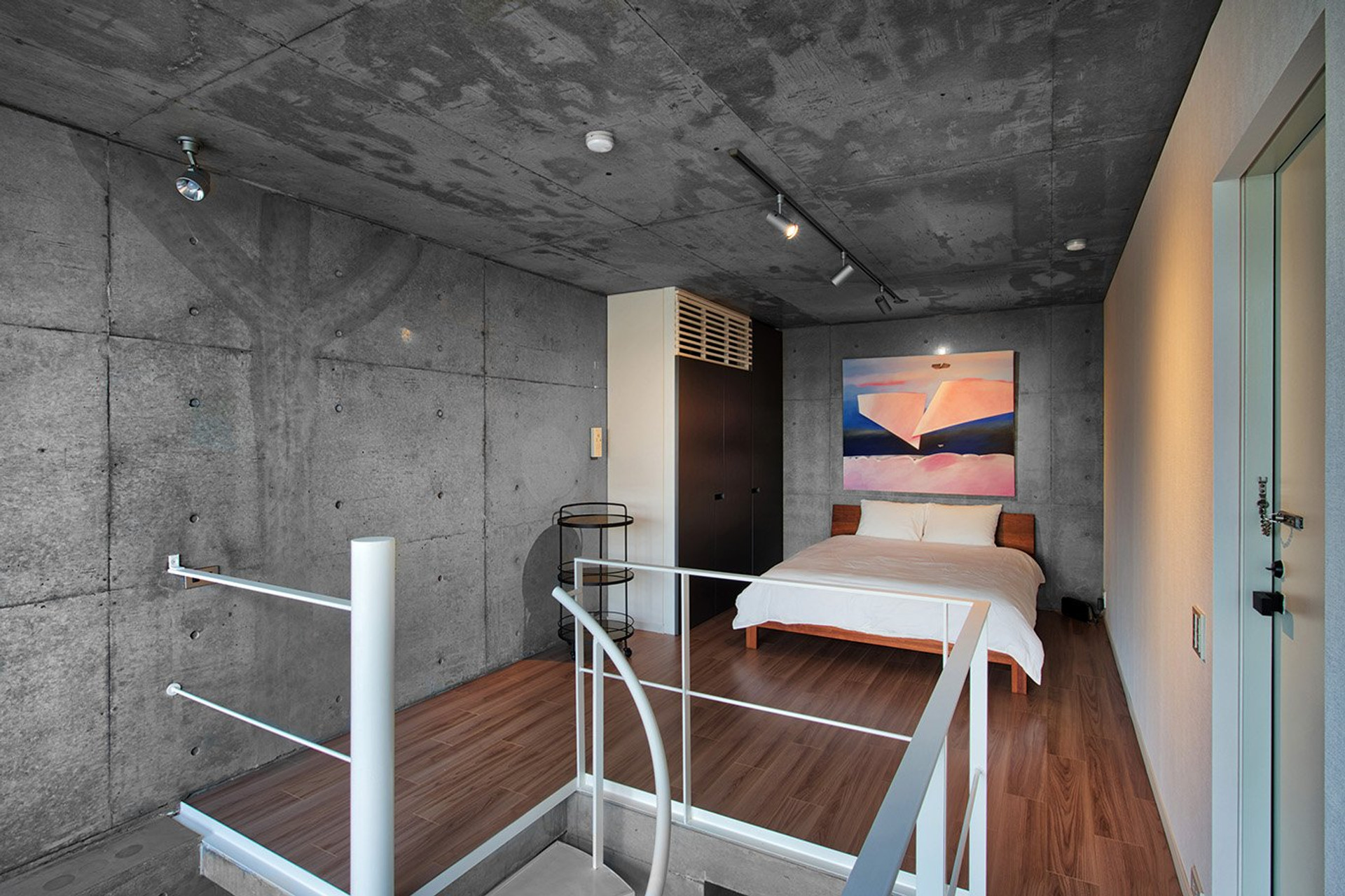 Bedroom with art and concrete walls