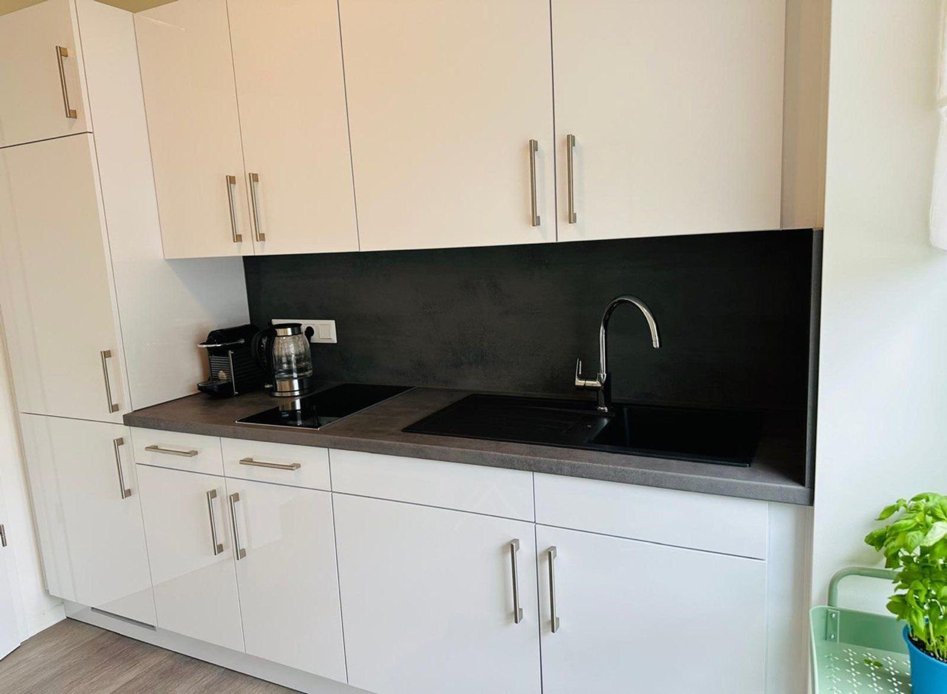 Modern white kitchen with dark backsplash