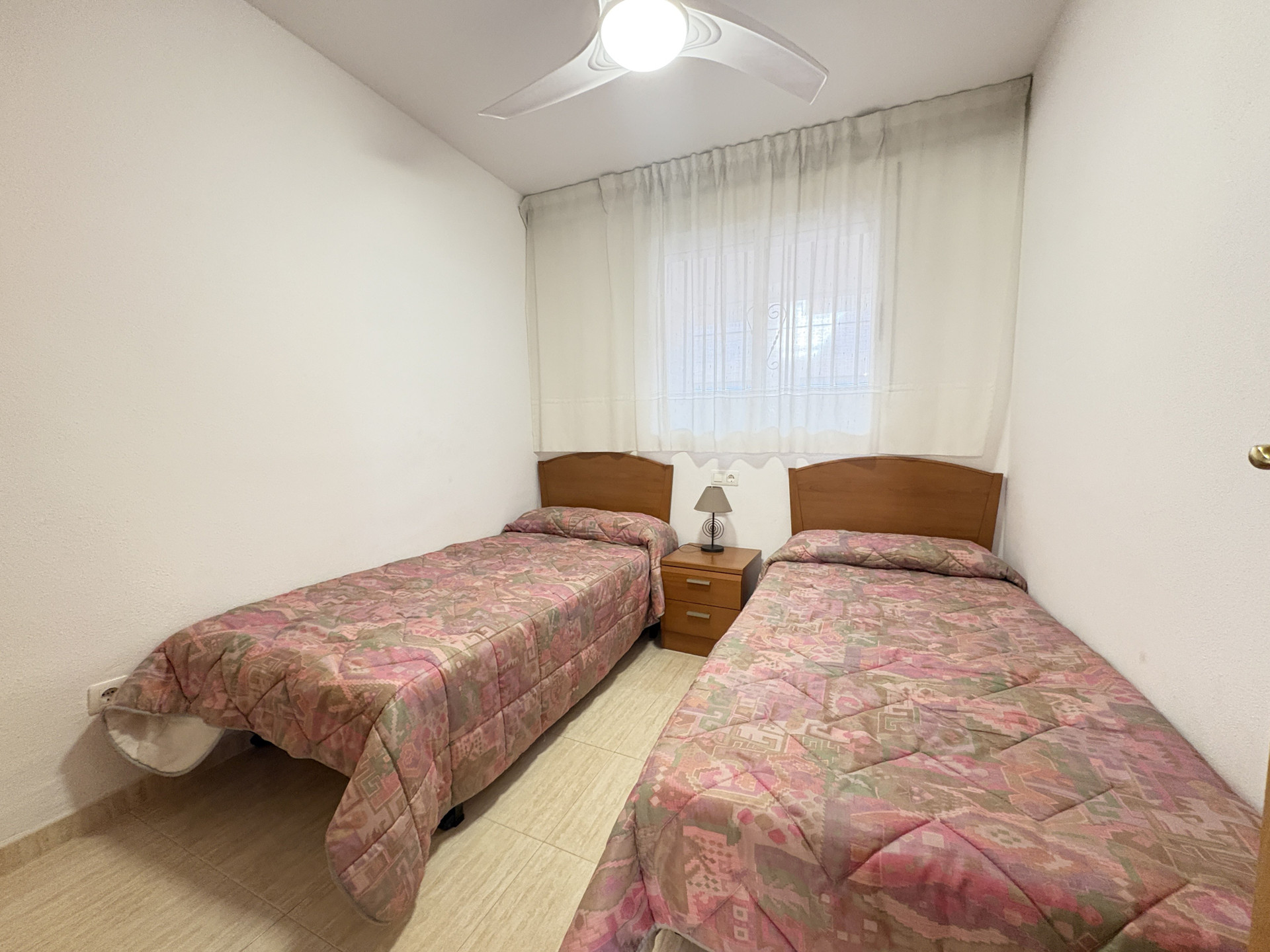 Twin bedroom with ceiling fan