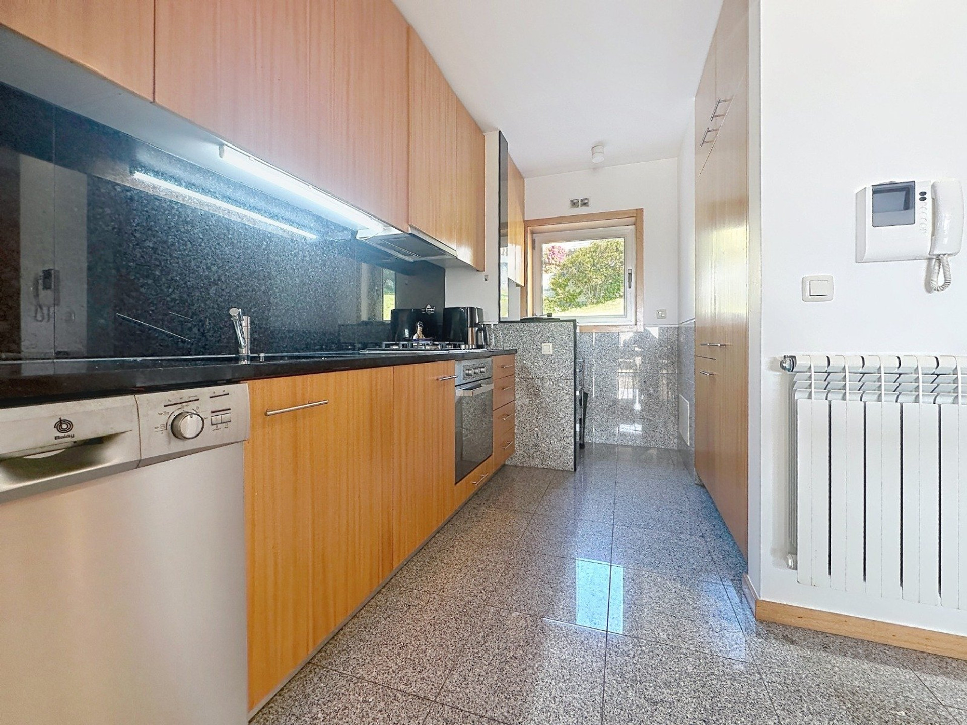 Galley kitchen with wooden cabinets