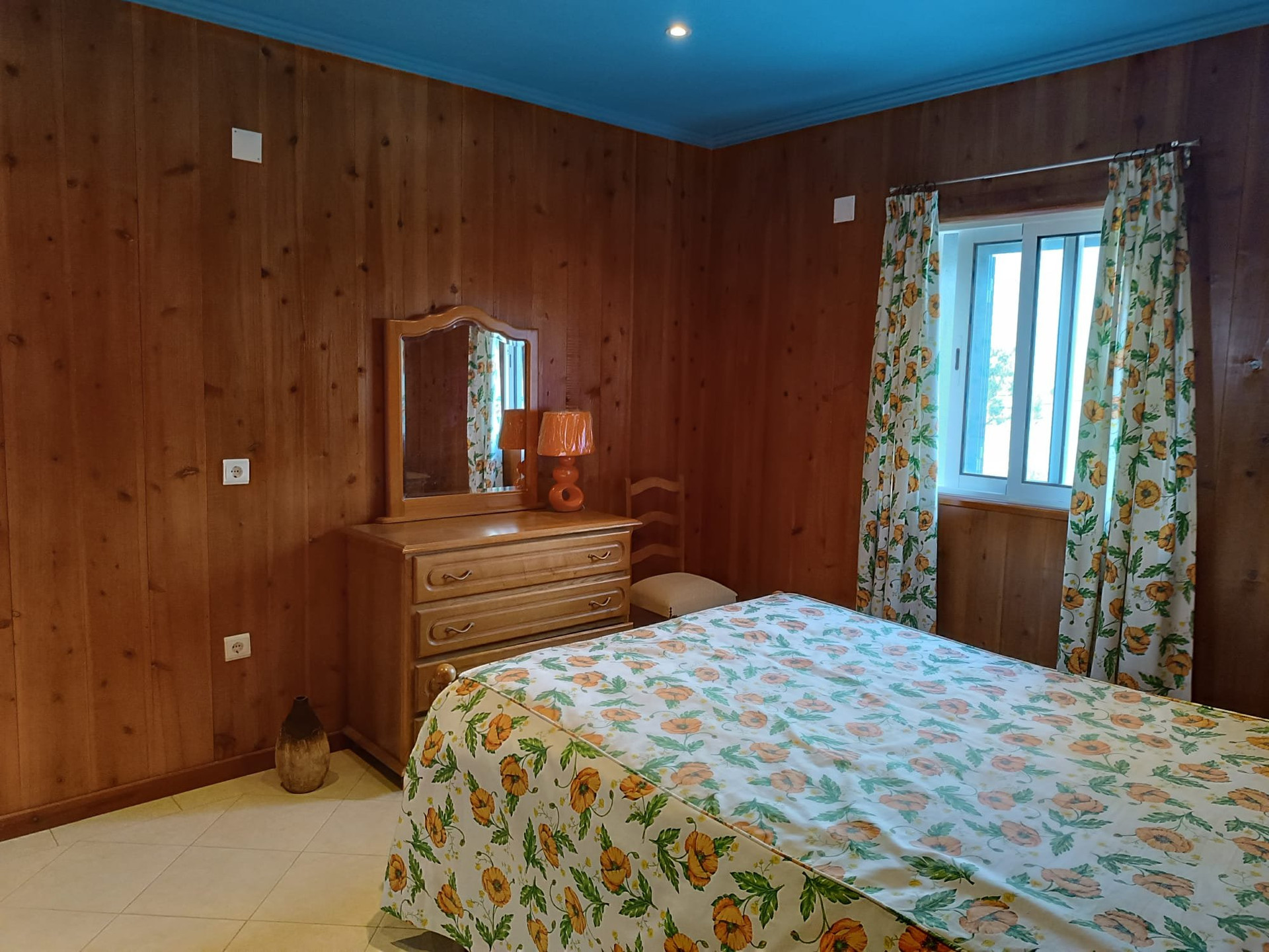 Bedroom with floral bedding and window