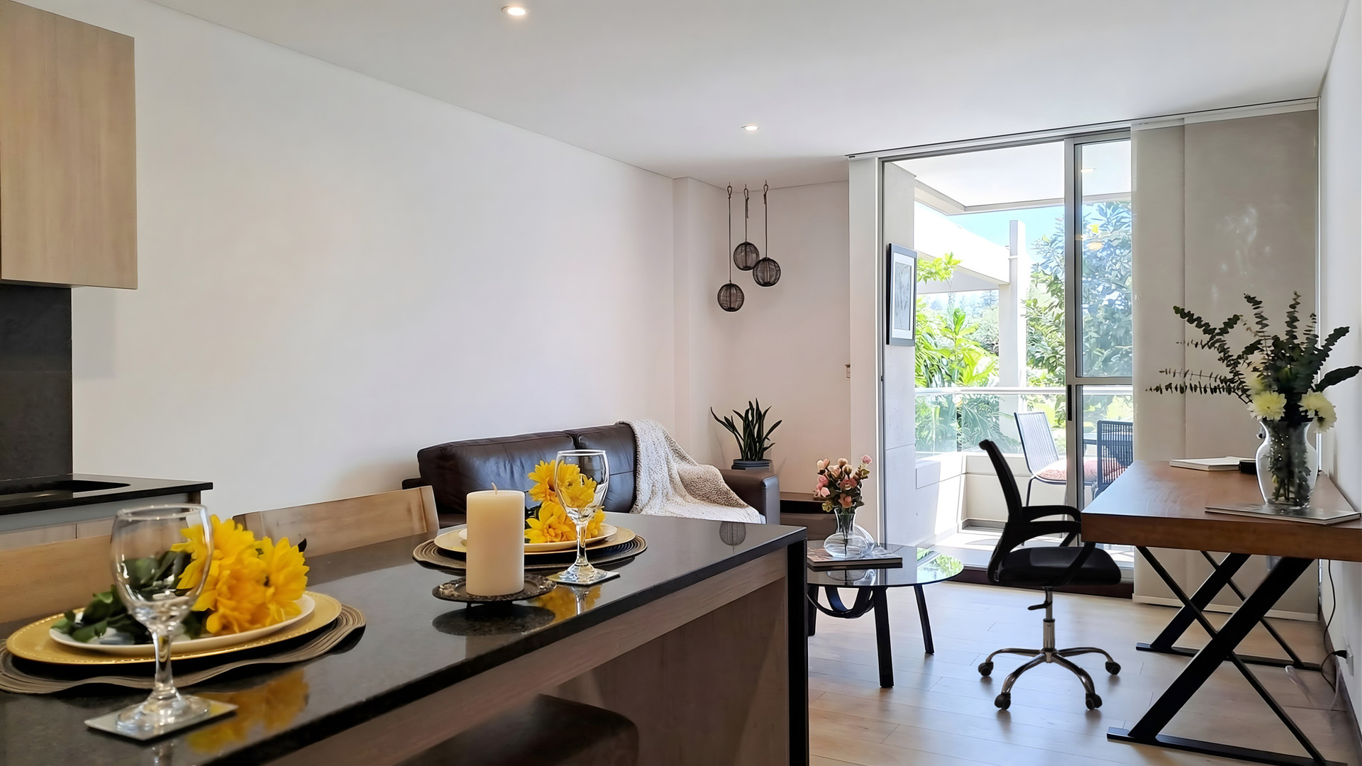 Open living space with kitchen, dining counter, work desk and balcony access, ideal for longer stays.